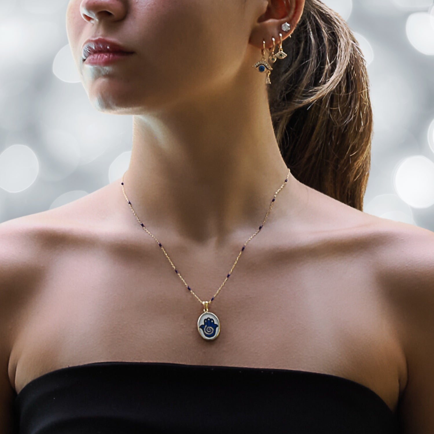 Model Wearing a Sterling Silver and Gold Hamsa Hand Necklace - A Symbol of Protection.