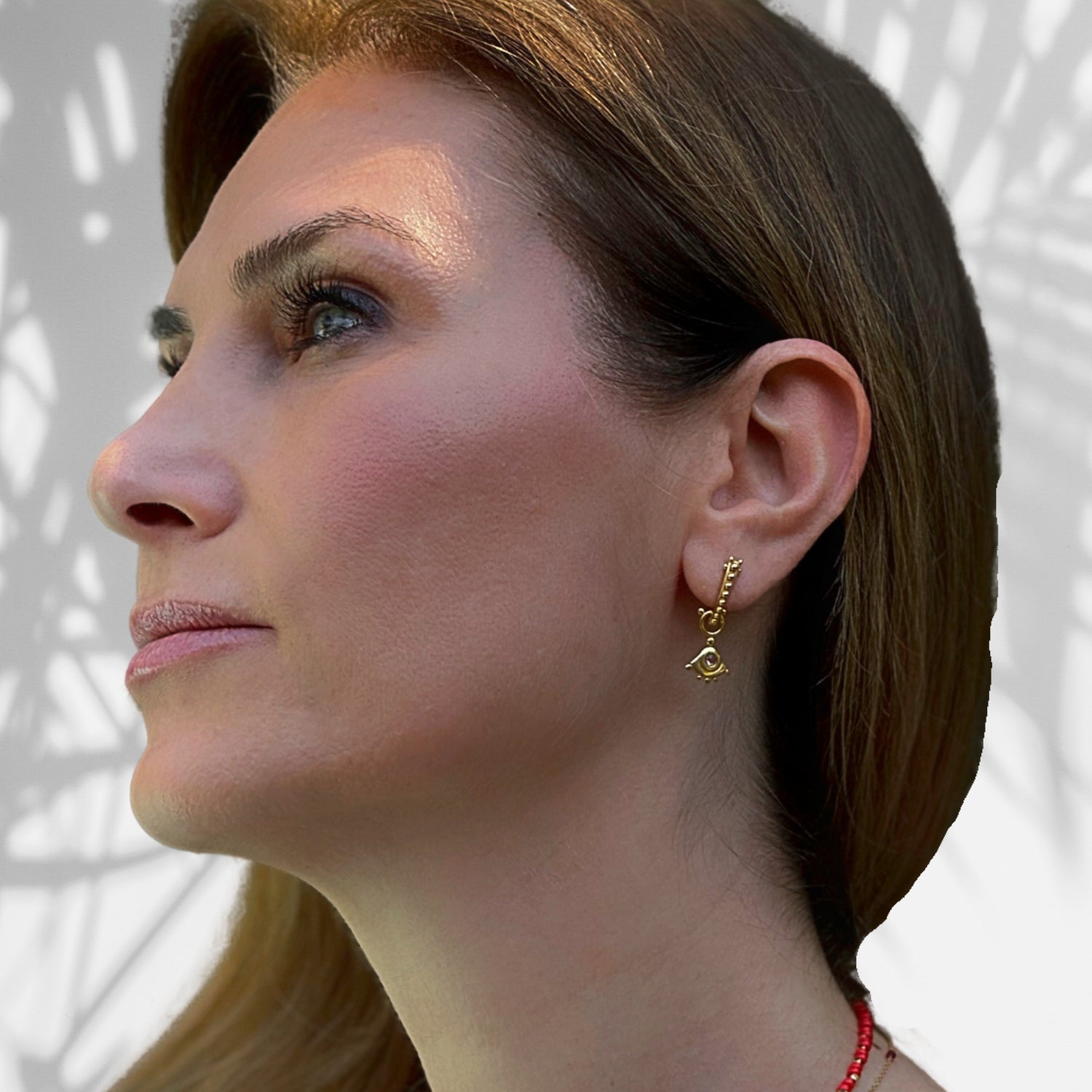 Sterling silver earrings plated with 18K gold, showcasing pink tourmaline gemstones and a protective evil eye