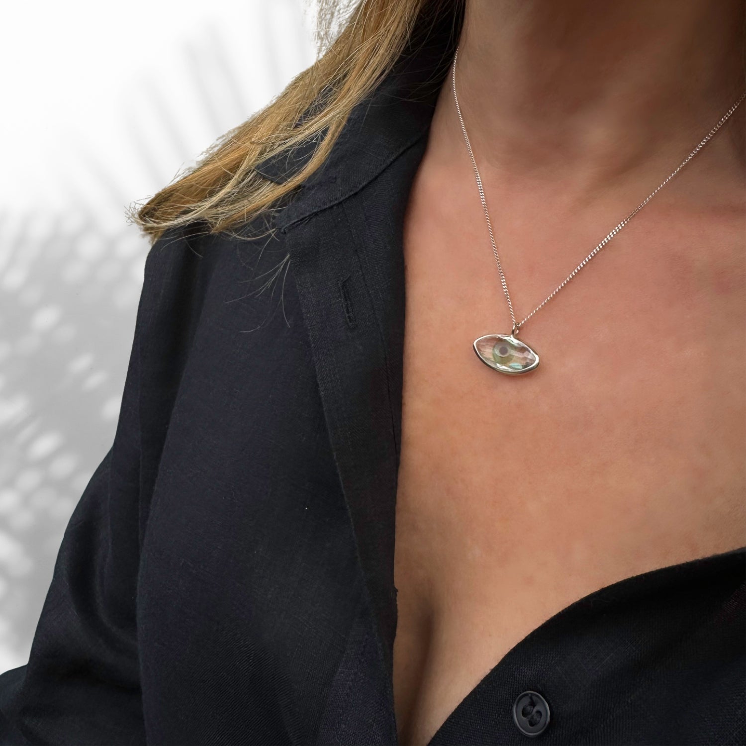 Adjustable Sterling Silver Necklace with Green Evil Eye Design.