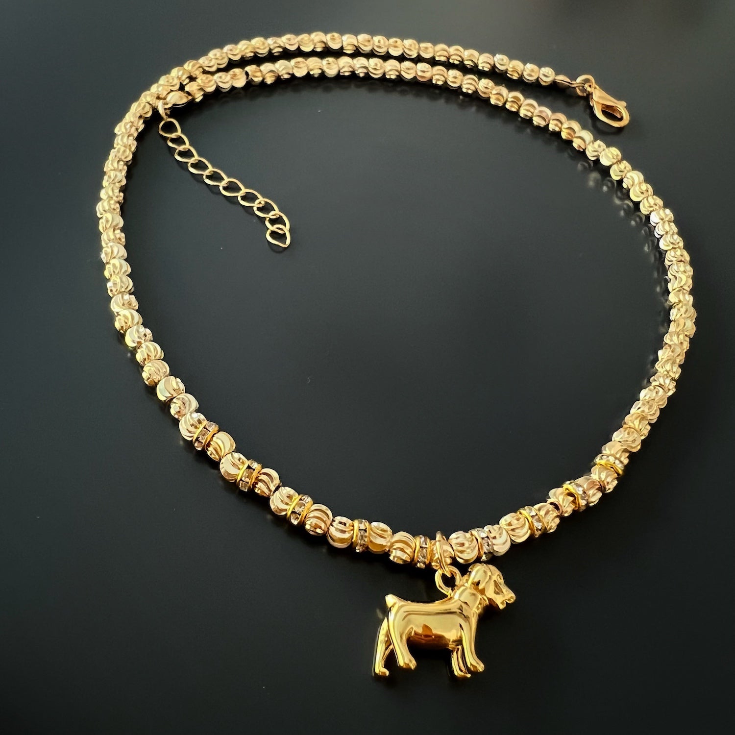  A detailed shot of the clasp and extender chain of the Happy Dog Gold Necklace, showcasing the craftsmanship and attention to detail in the construction of the necklace.