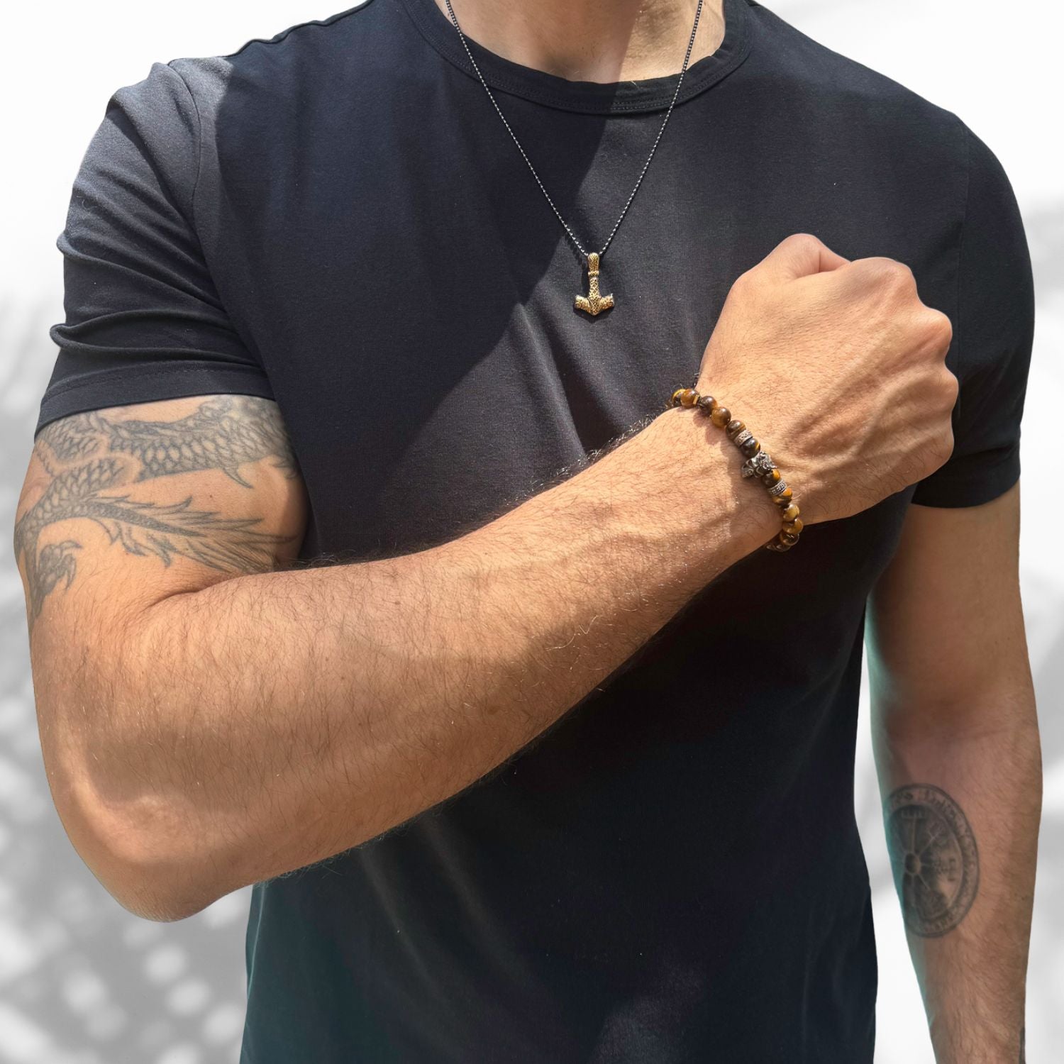 Close-up of bronze skull charm bracelet with tiger’s eye stones for grounding and strength.