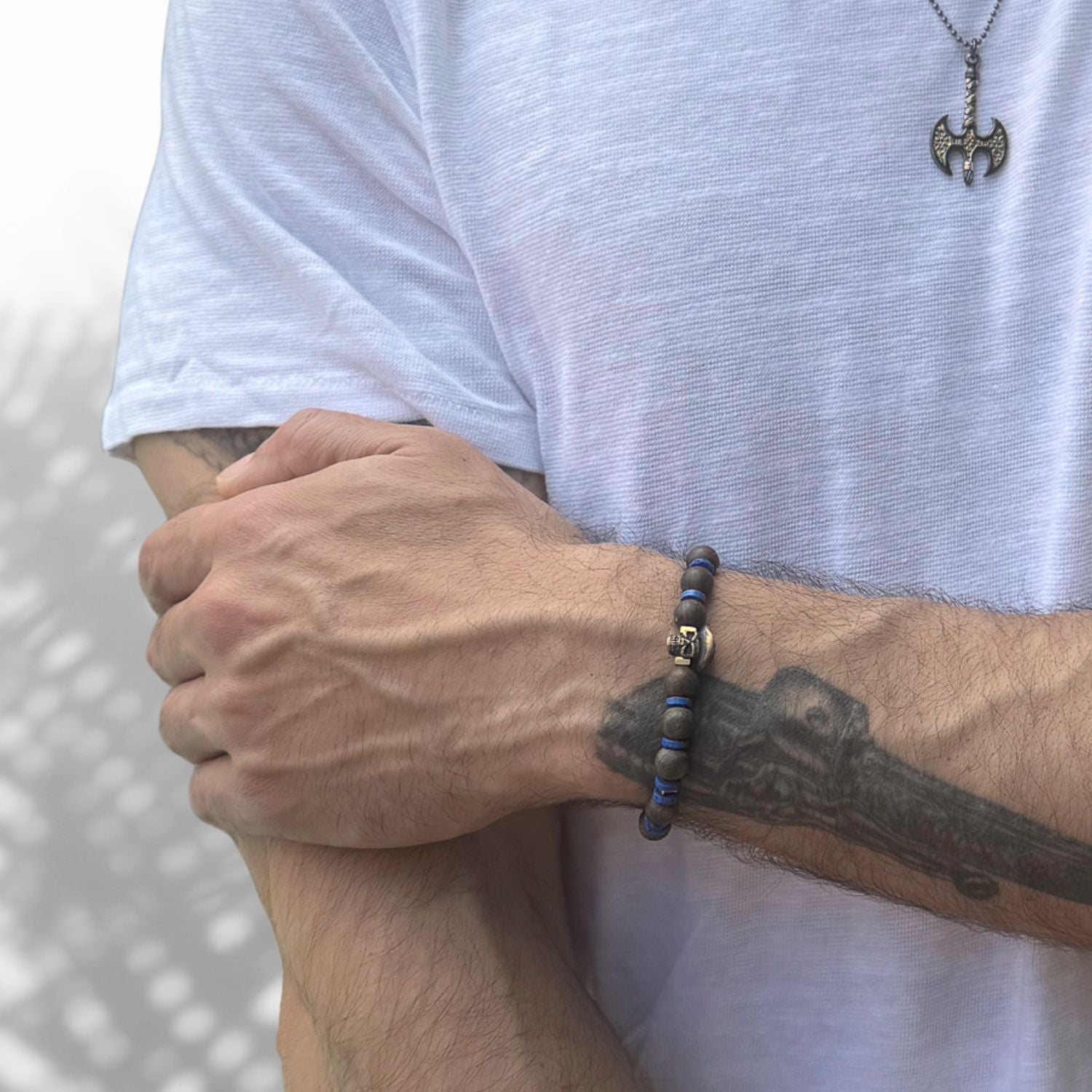 Handmade bracelet featuring 8mm bronzite beads, bronze skull with hat, and bold blue accents.