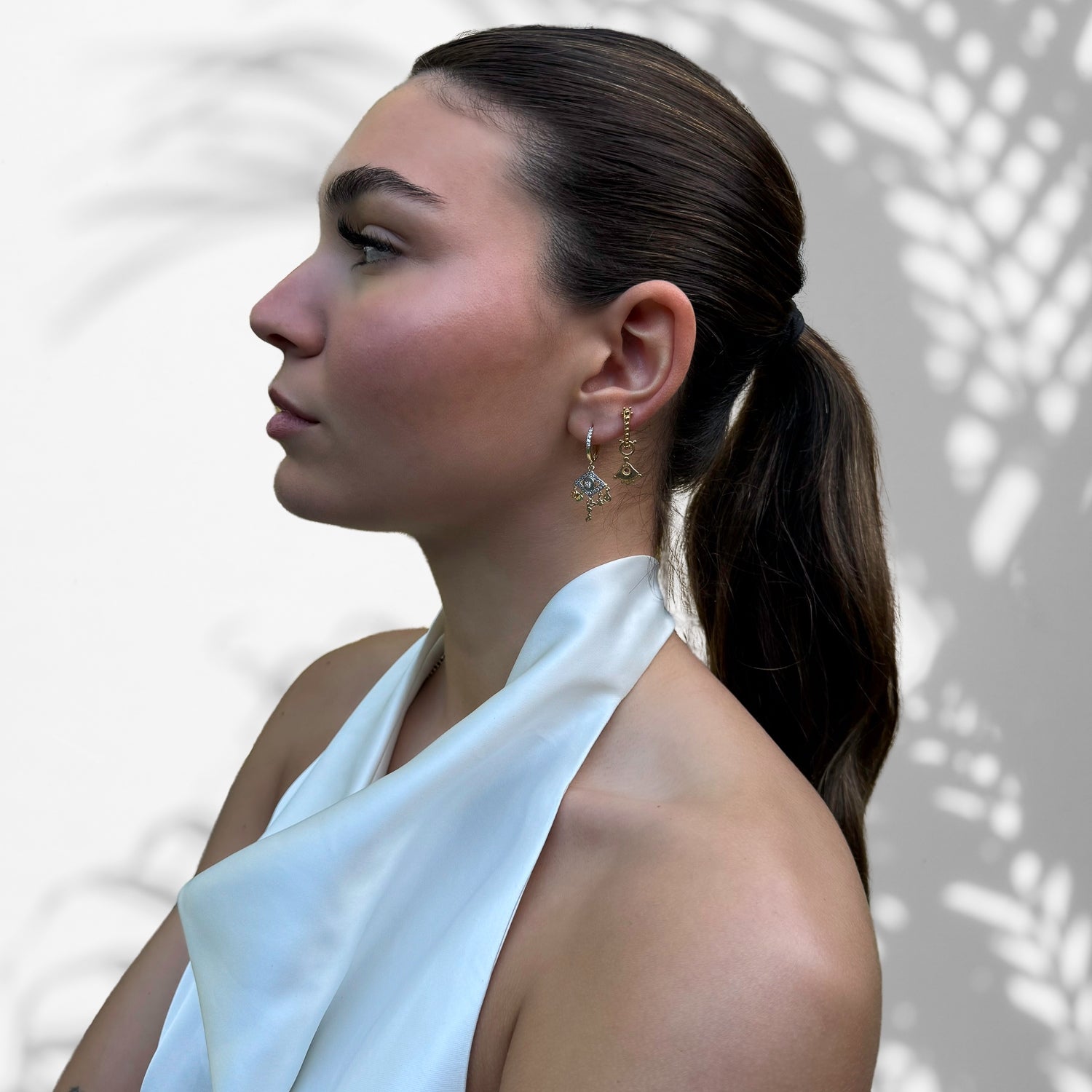 Fashionable Model Displaying Symbolic Charms on Gold Earrings