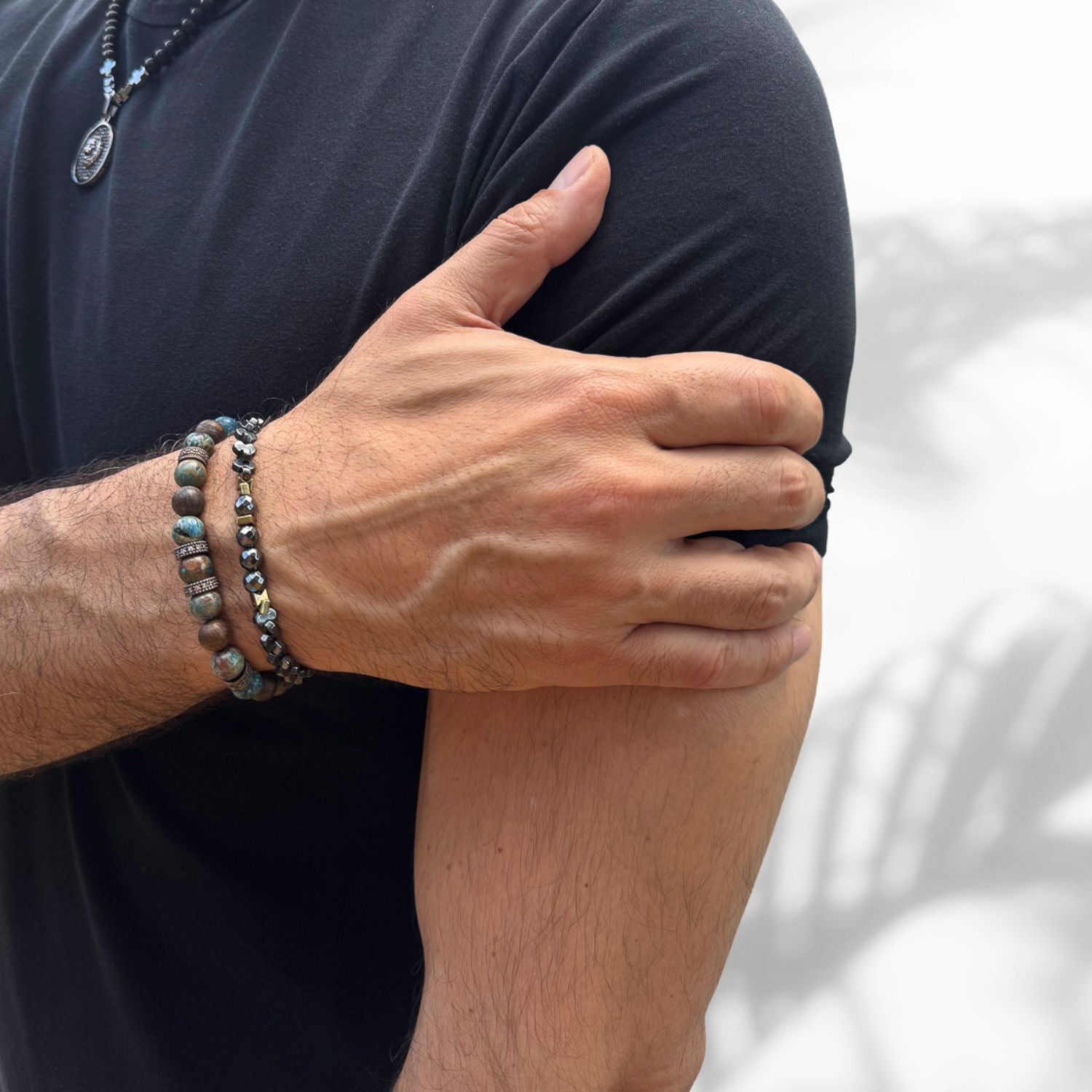 detailed view of hematite stones and gold-plated bead on men's bracelet