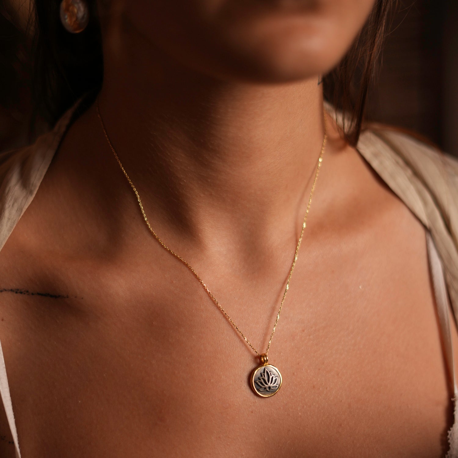 Sterling silver necklace with a gold-plated lotus flower pendant, embodying the essence of purity and spiritual growth.