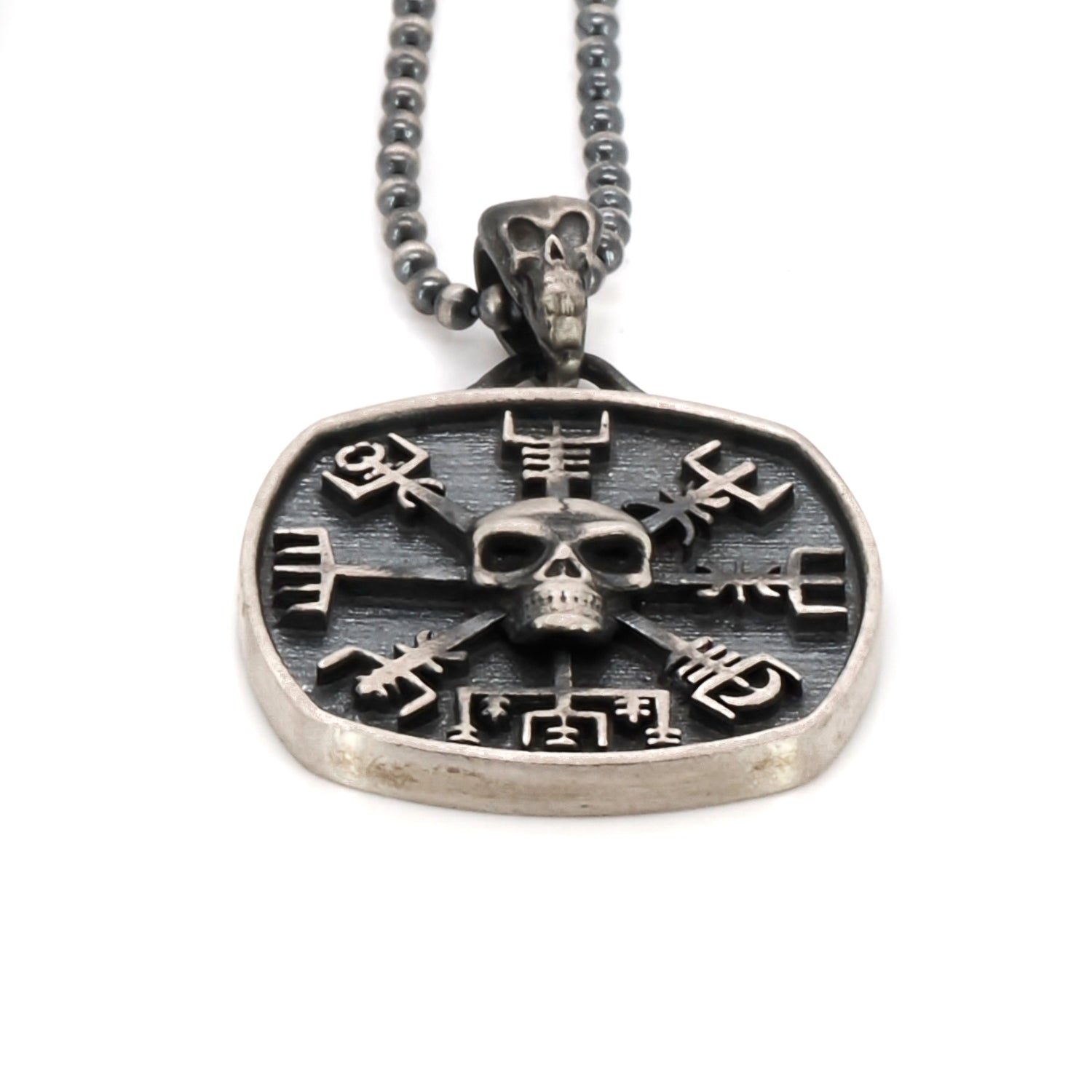 close up of skull and vegvisir symbol pendant on sterling silver chain