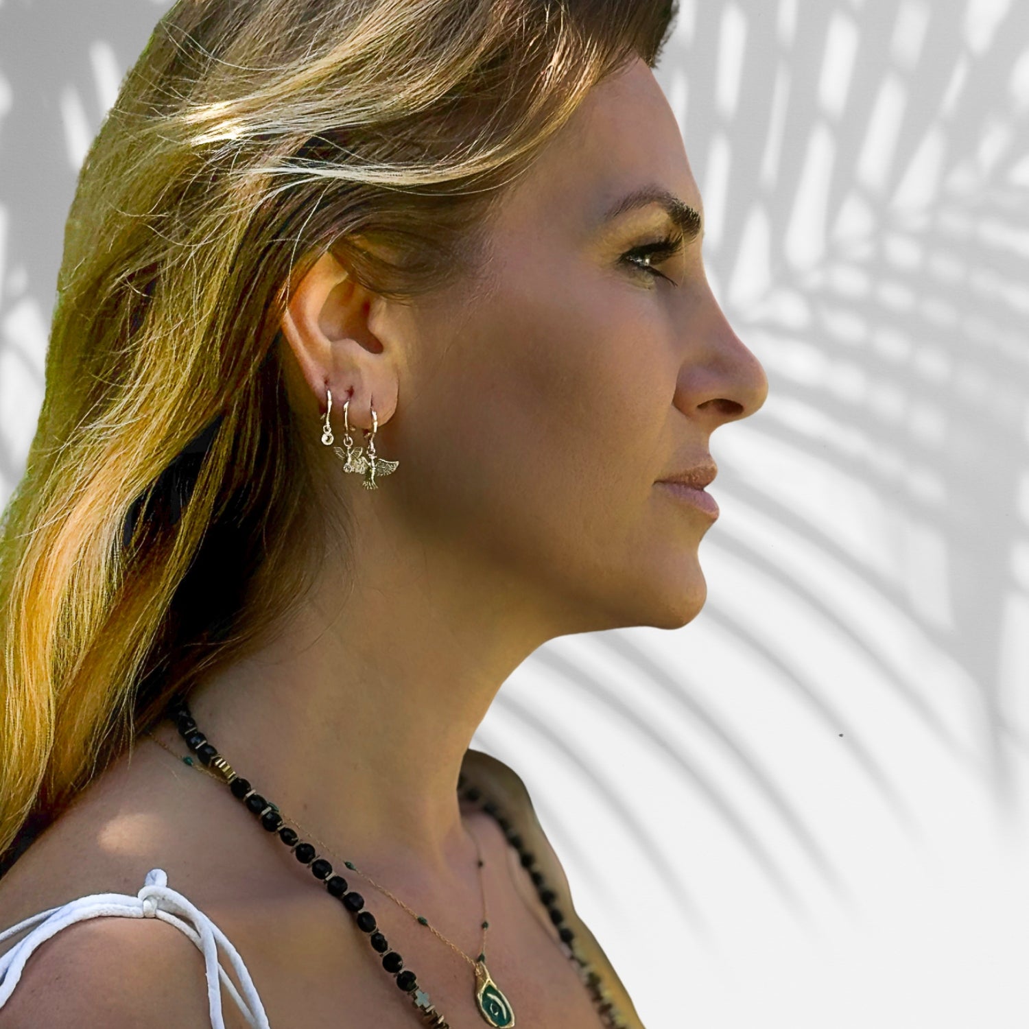 Handmade gold earrings featuring three spiritual bird designs, adorned with cubic zirconia for added luxury