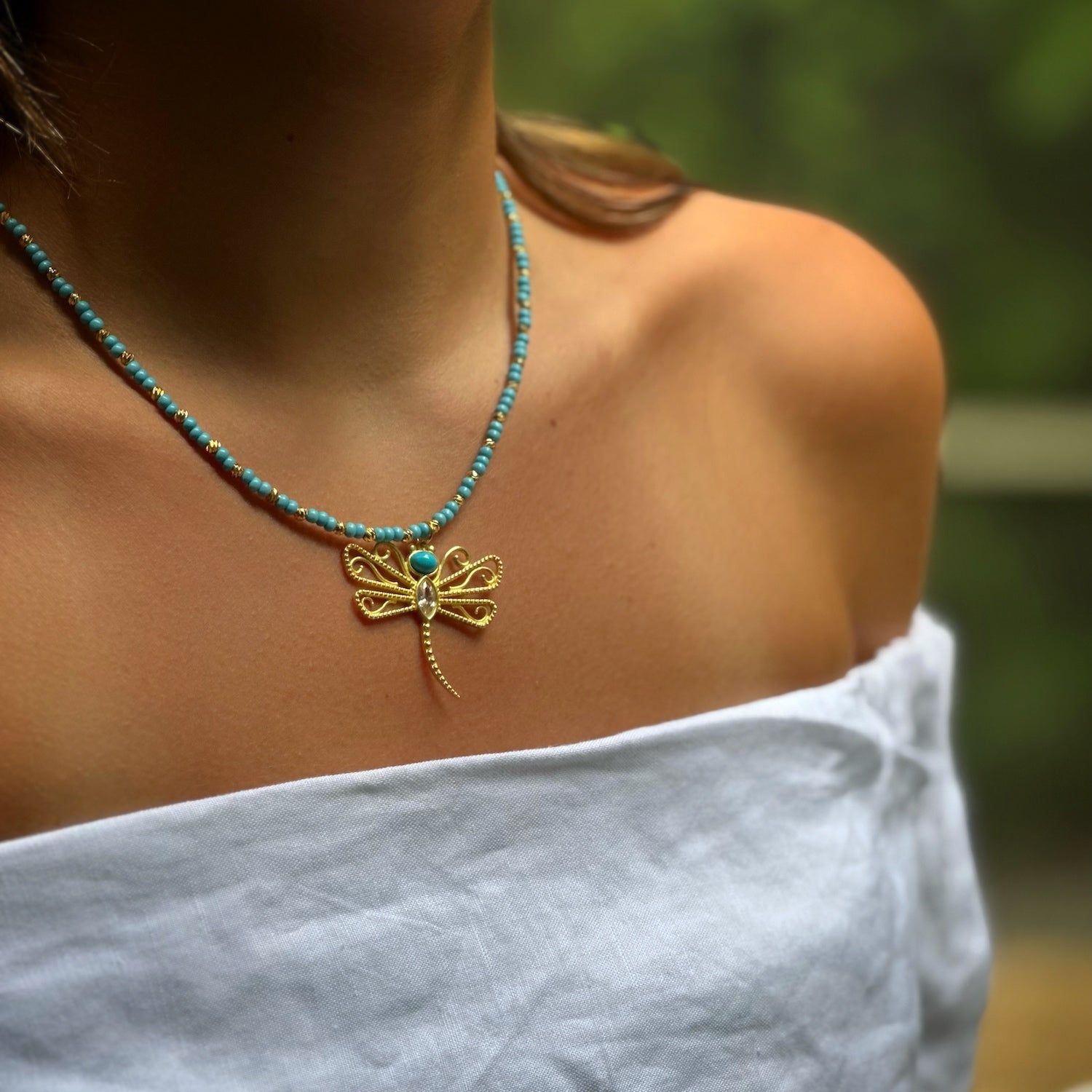 Model Embraces Transformation with Turquoise Dragonfly Necklace.