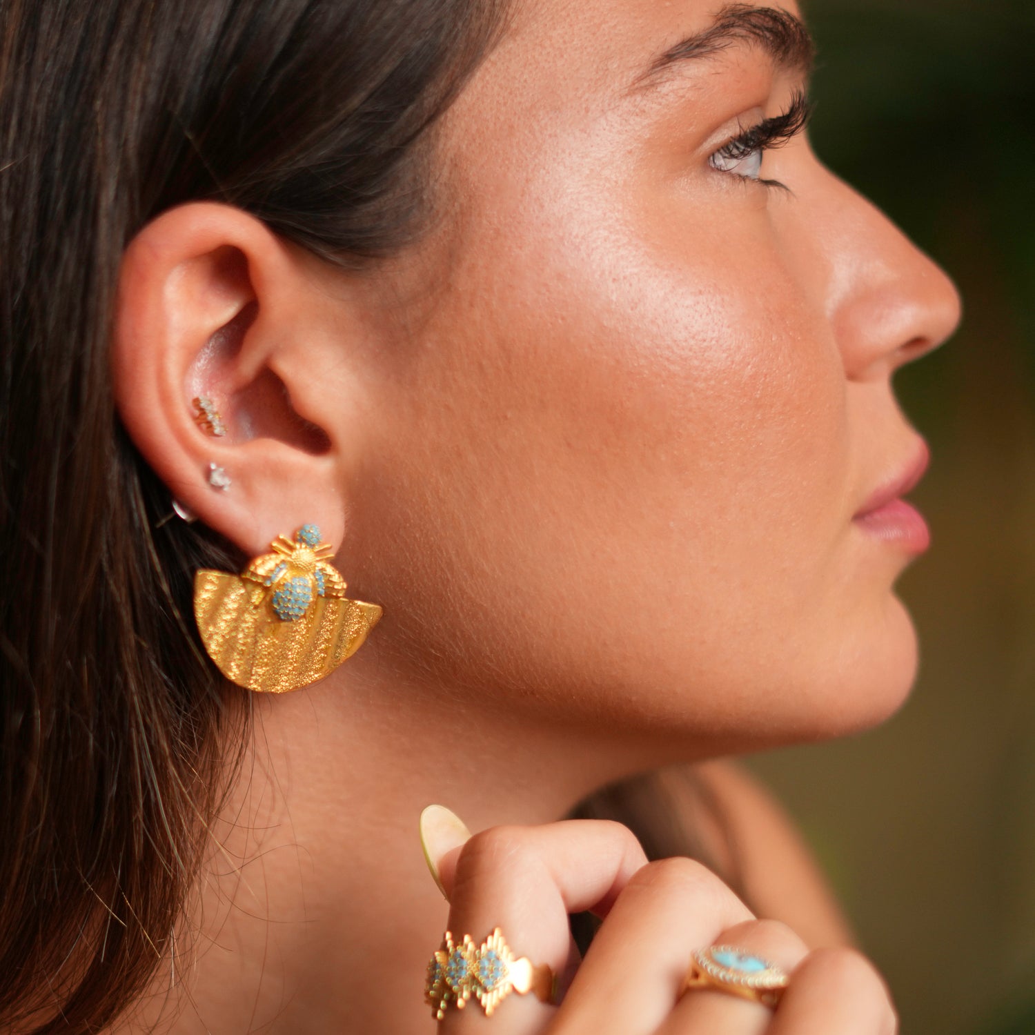 Elegant chunky earrings with a gold half-moon design, adorned with turquoise stones and a honey bee accent, crafted in 24k gold plating.