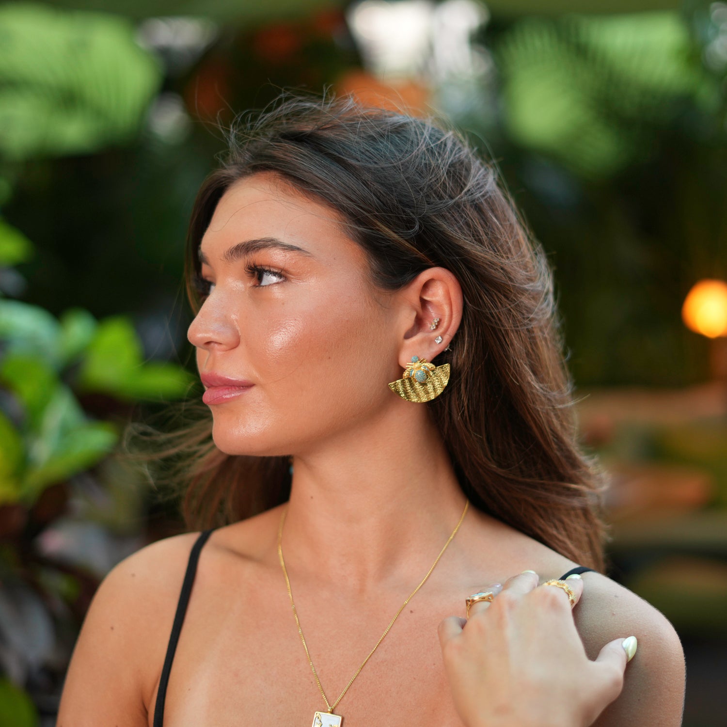Luxurious gold earrings featuring a half-moon shape with turquoise accents and a honey bee motif, crafted to add a touch of abundance to your look.