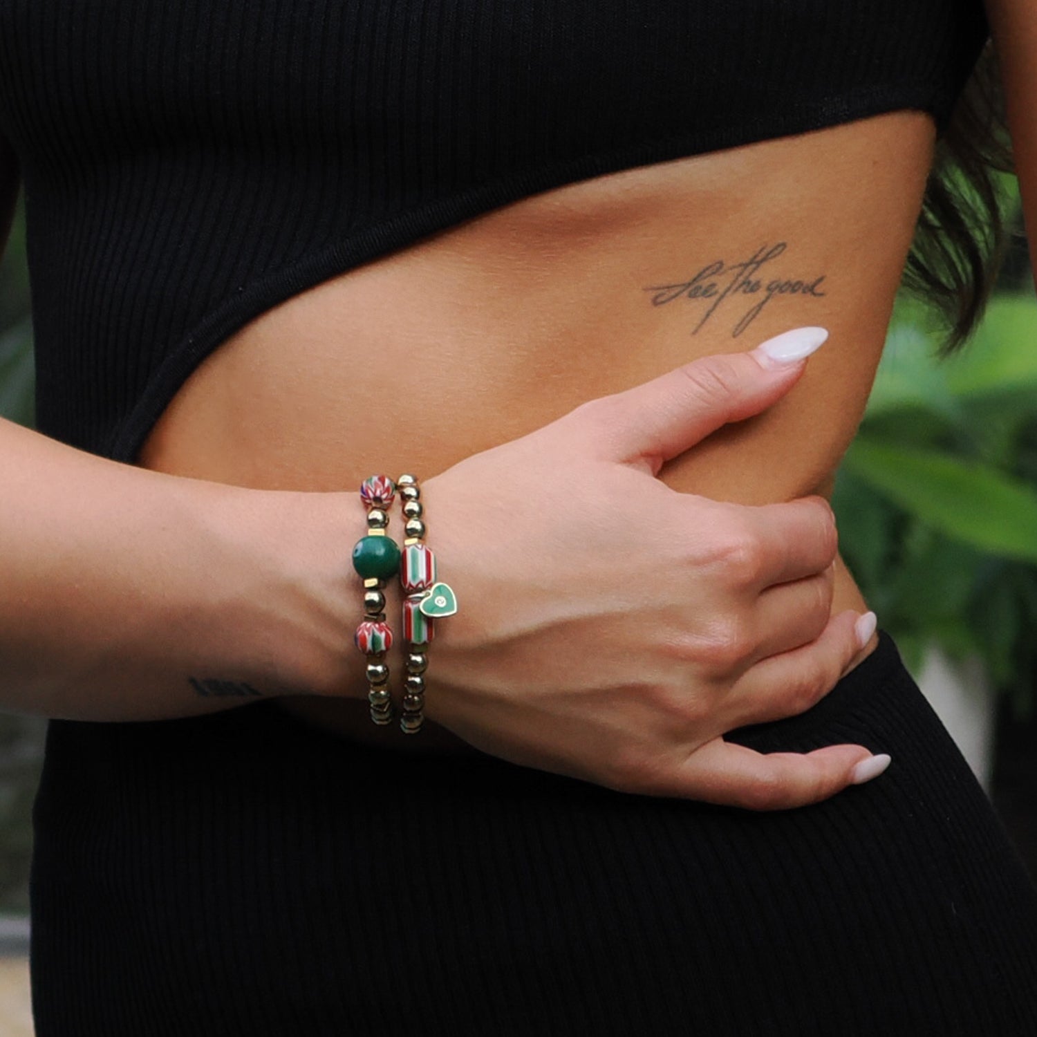 Handcrafted bracelet set featuring a green heart charm, gold hematite beads, and a green glass Evil Eye bead.