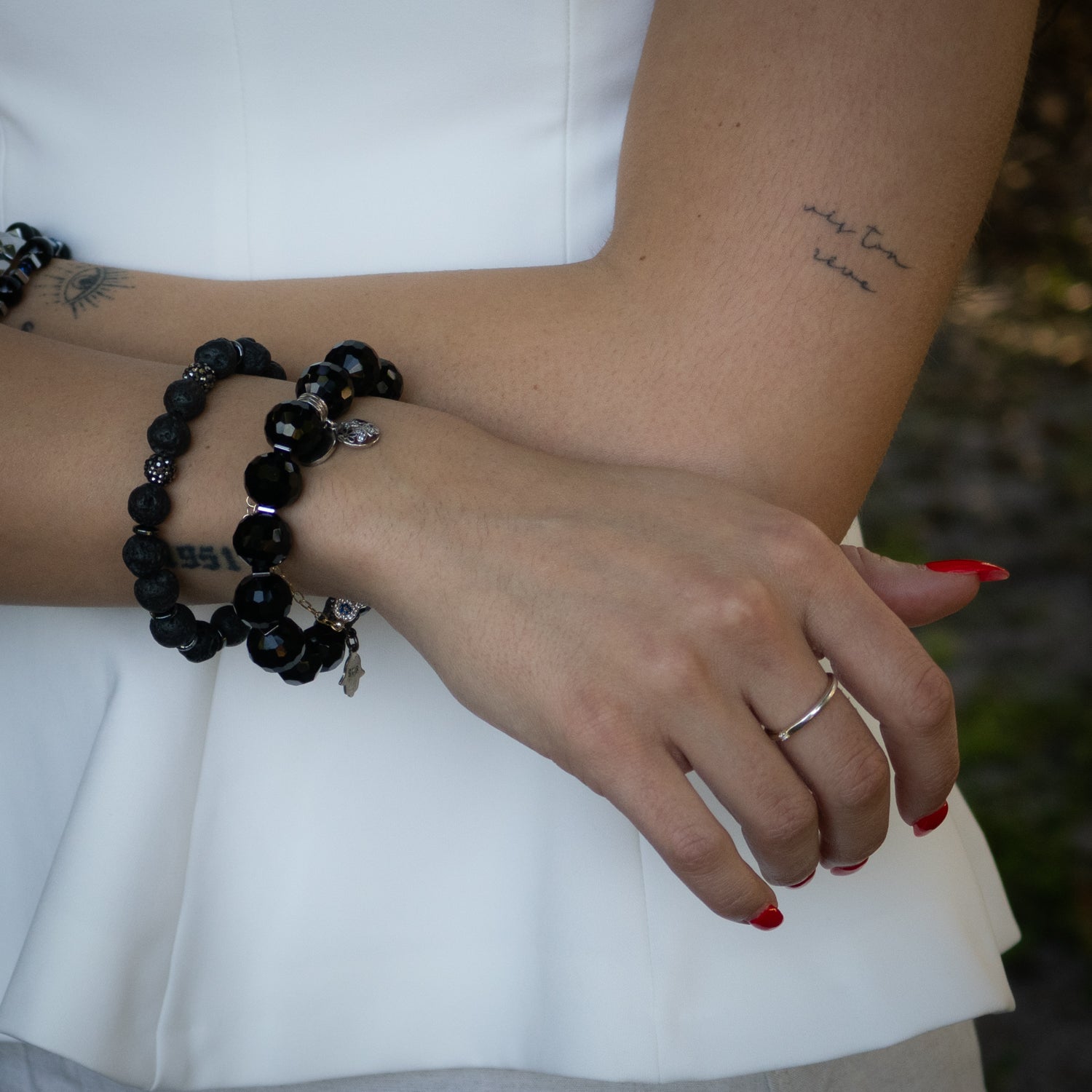 Black lava rock and crystal bead bracelet featuring a silver plated Swarovski charm.