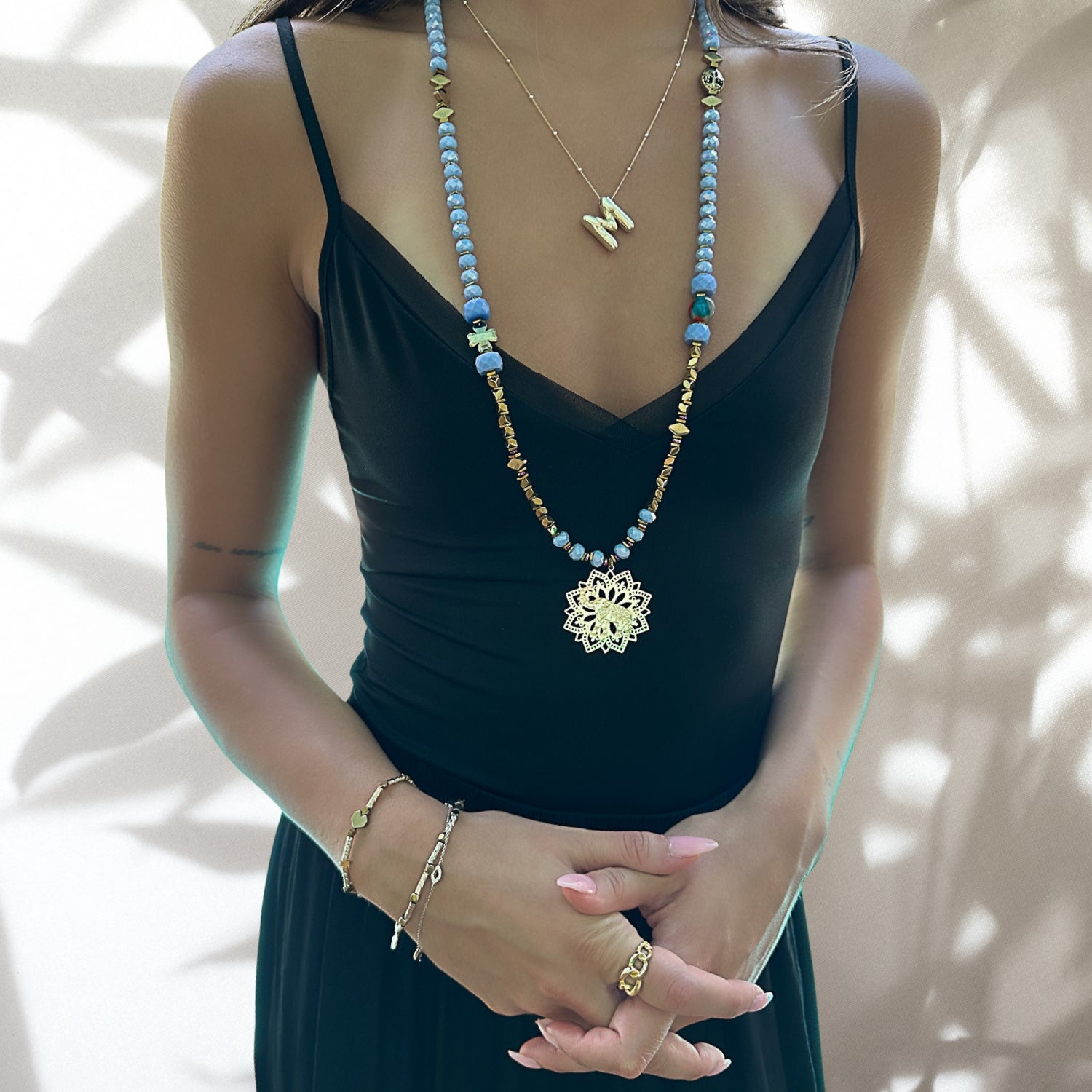 Model wearing the Blue Magic Gold Elephant Necklace, showcasing its elegant design and complementing the neckline.