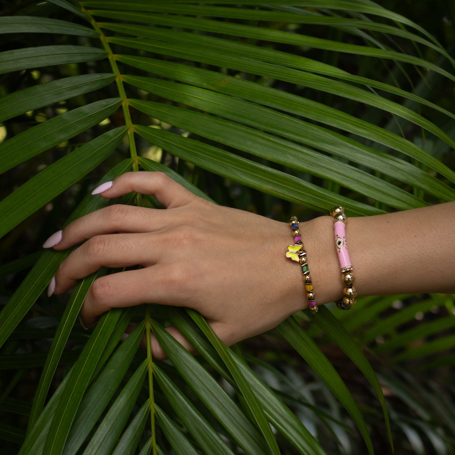 Vibrant bracelet stack with colorful pearls, African beads, and spiritual gold symbols