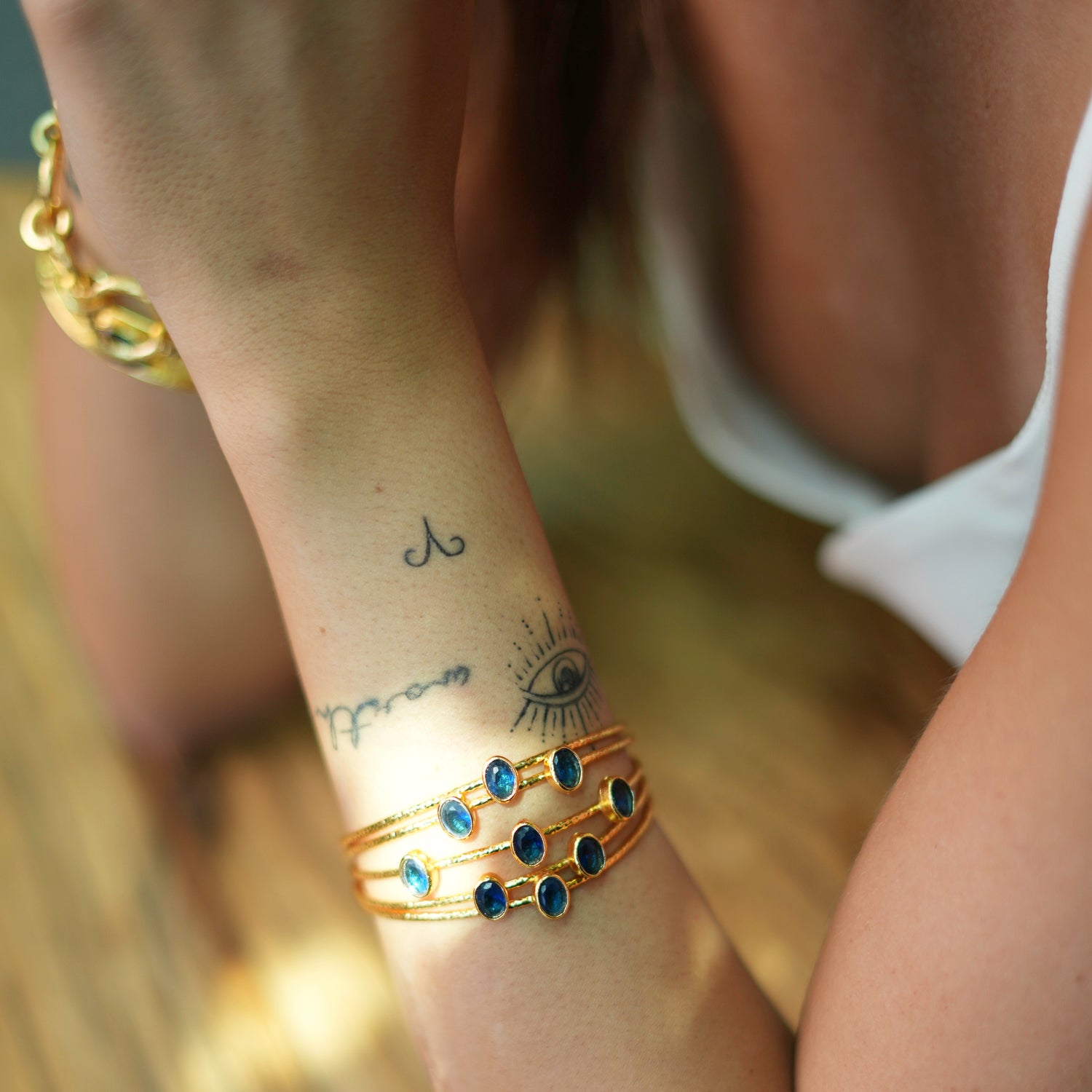 Bold chunky cuff bracelet with 24k gold plating, designed with five thin gold wires and embellished with sapphire stones, adjustable size.