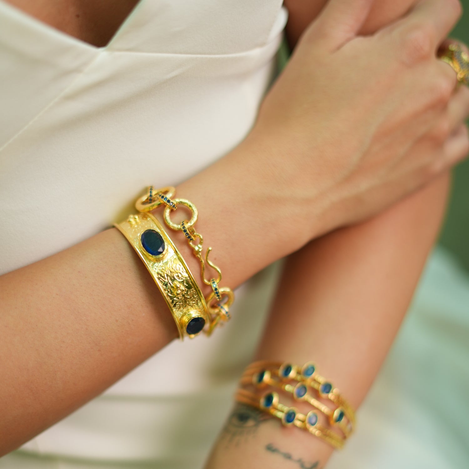 24K Gold Cuff Bracelet with Sapphire Gemstones and Intricate Detailing for a Regal Fashion Statement