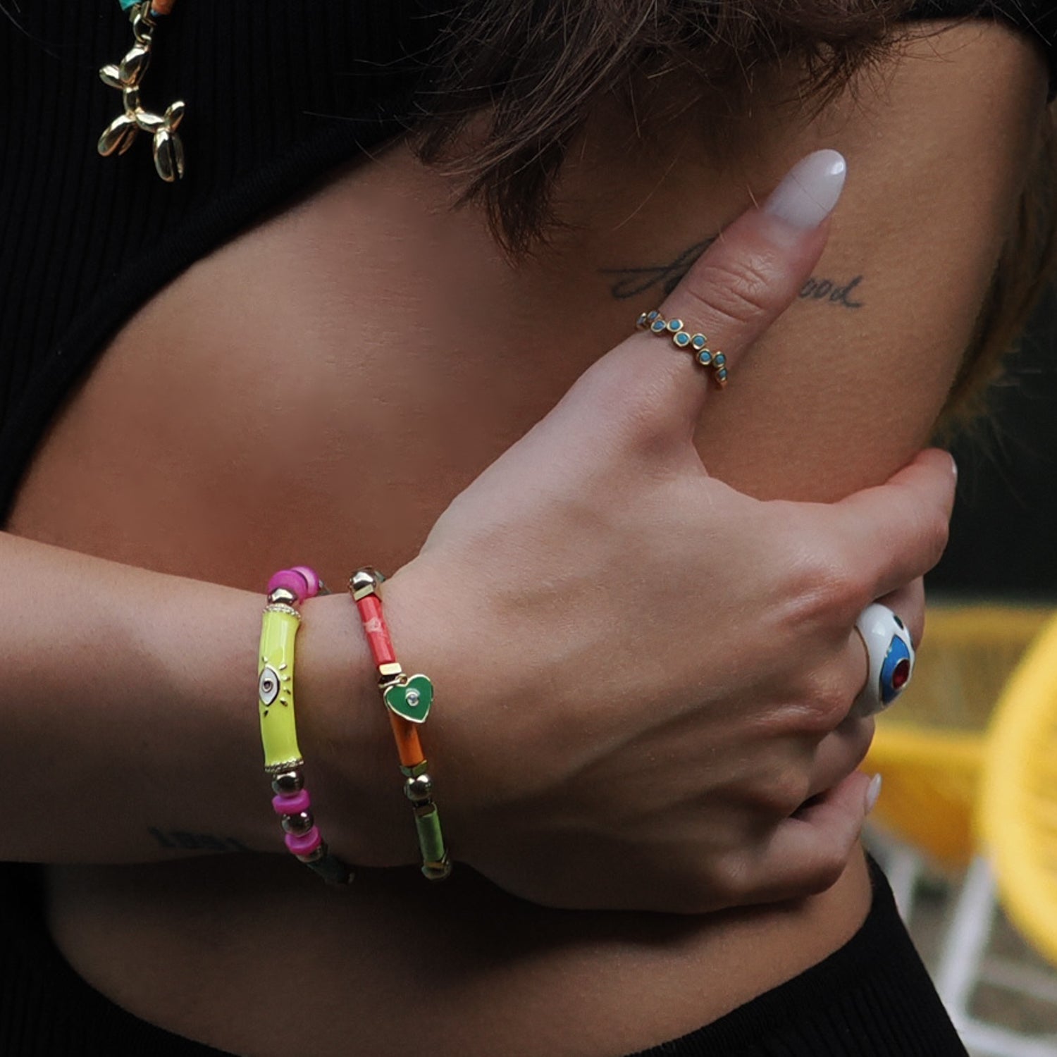 Handcrafted bracelet set featuring a neon yellow enamel Evil Eye tube and green heart charm with colorful jasper stones.