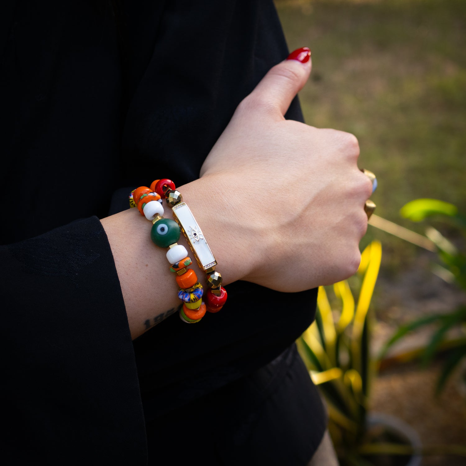 Gold and enamel evil eye bracelet paired with joyful, colorful ceramic beads