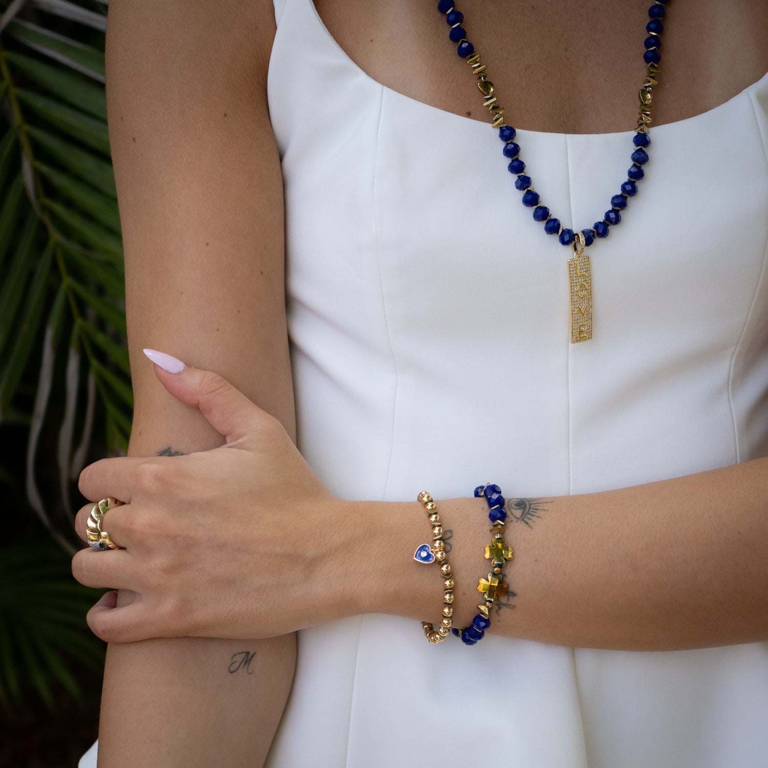 Handmade gold and blue bracelet set featuring enamel heart charms and crystal details