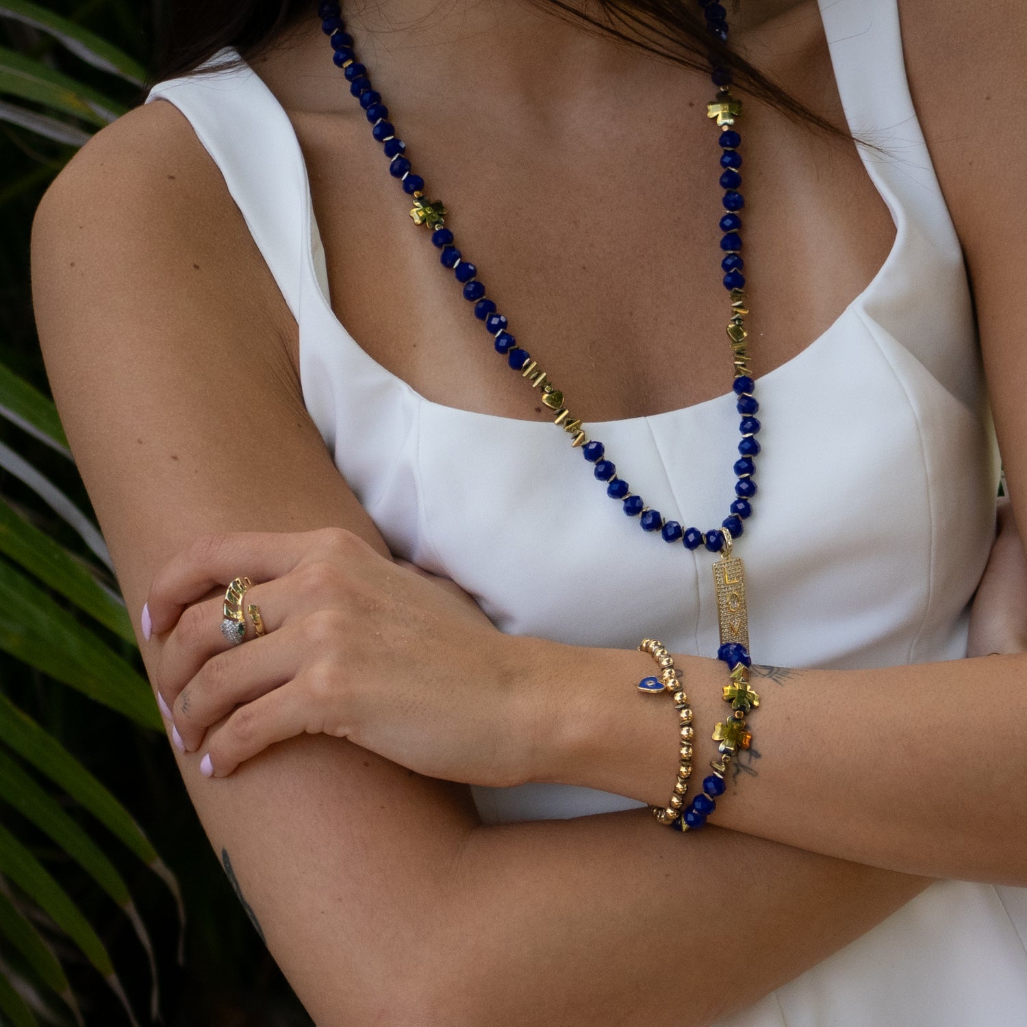 Wrist view of Deep Love gold and blue charm bracelet set for peace and connection