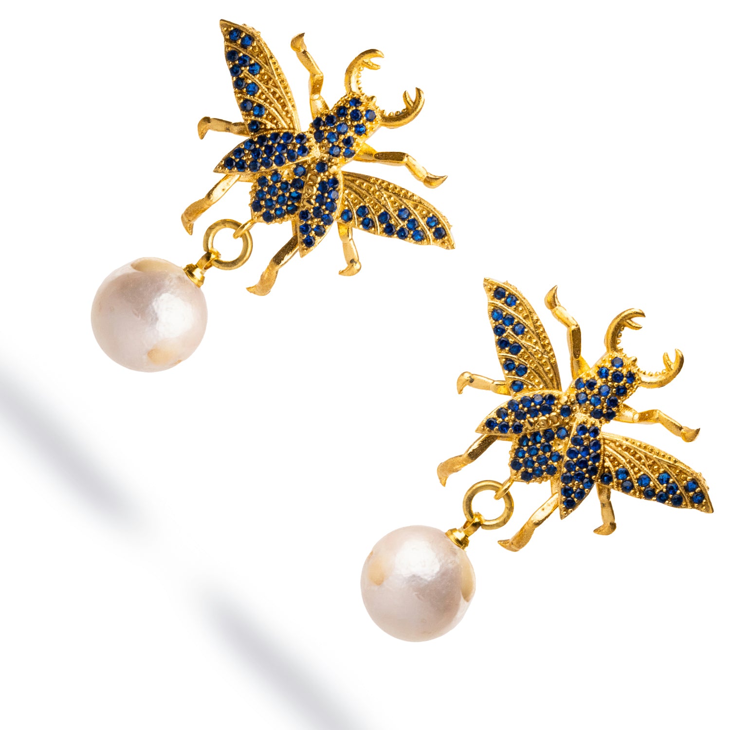 Statement chunky earrings with a gold queen bee motif, sapphire accents, and a pearl drop, combining sophistication with spiritual elegance.