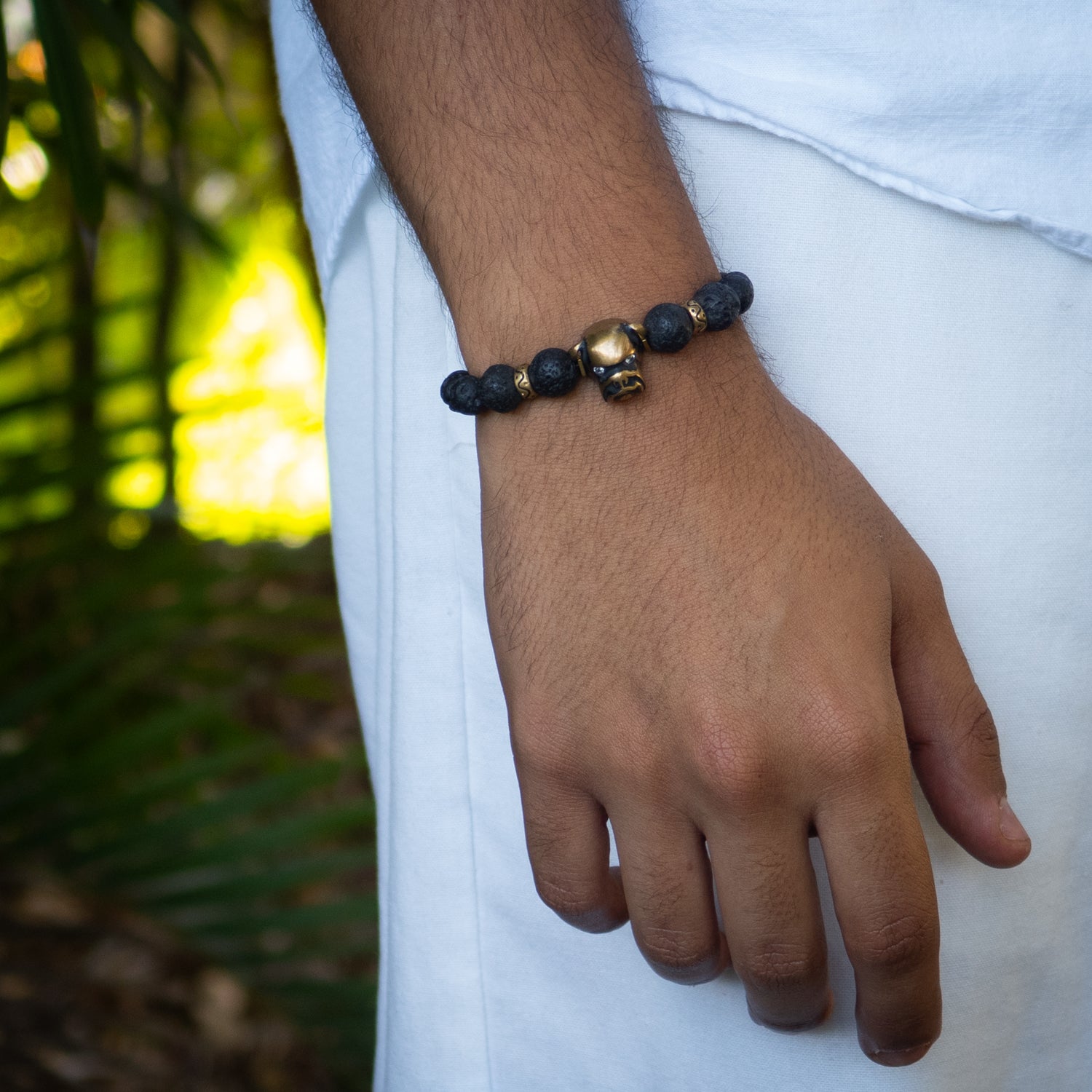 Black lava rock bracelet with bronze dog charm featuring zircon eye and gold hematite spacers.