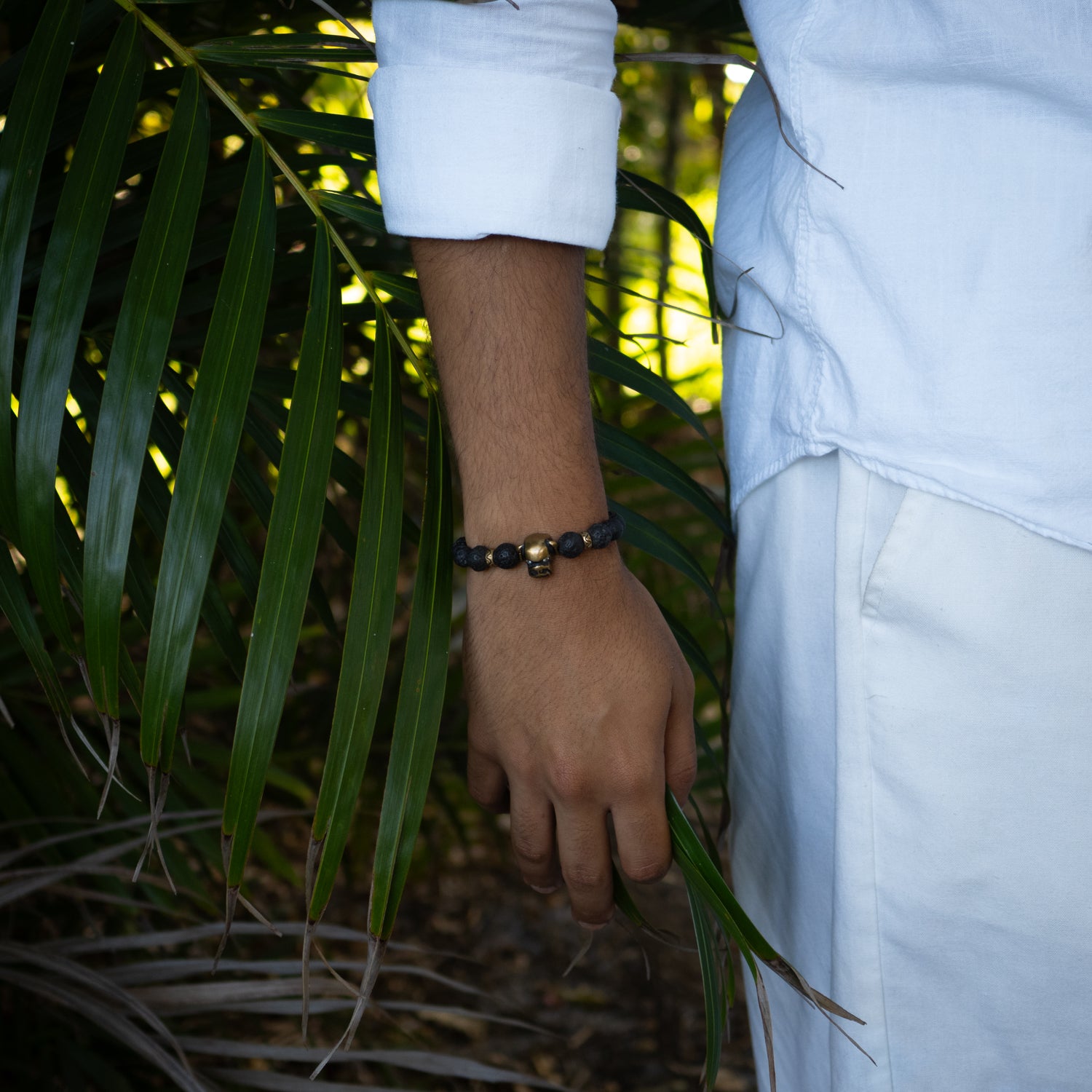 Handmade bracelet combining lava rock beads, tiger eye accents, and bronze dog and skull charms.