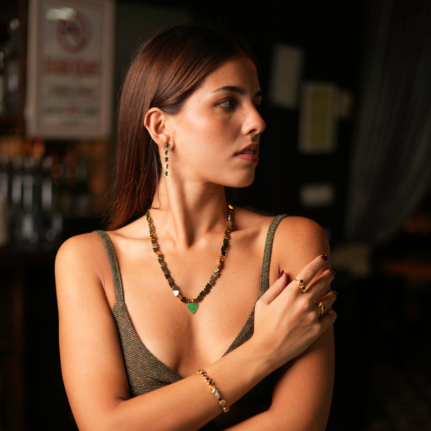 Stunning 24k gold-plated earrings with a linear design of green emeralds, providing a touch of elegance and sparkle.