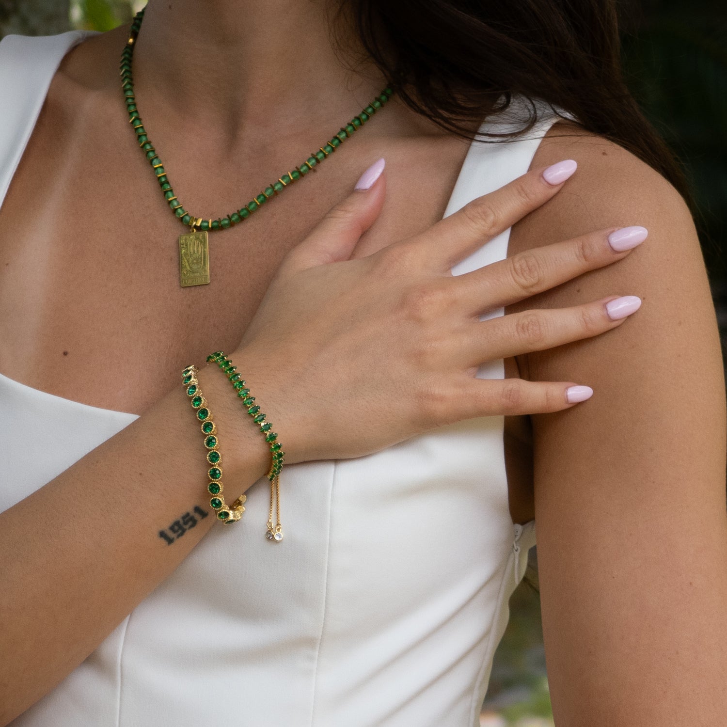 Wrist view of emerald green and gold bracelet for confidence and style