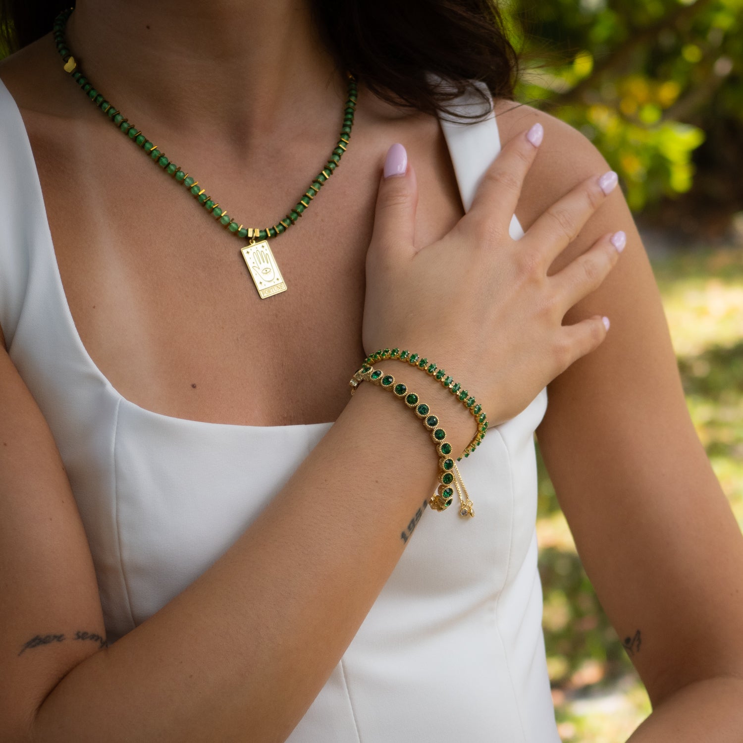 Elegant gold chain bracelet with deep green stones symbolizing growth and balance