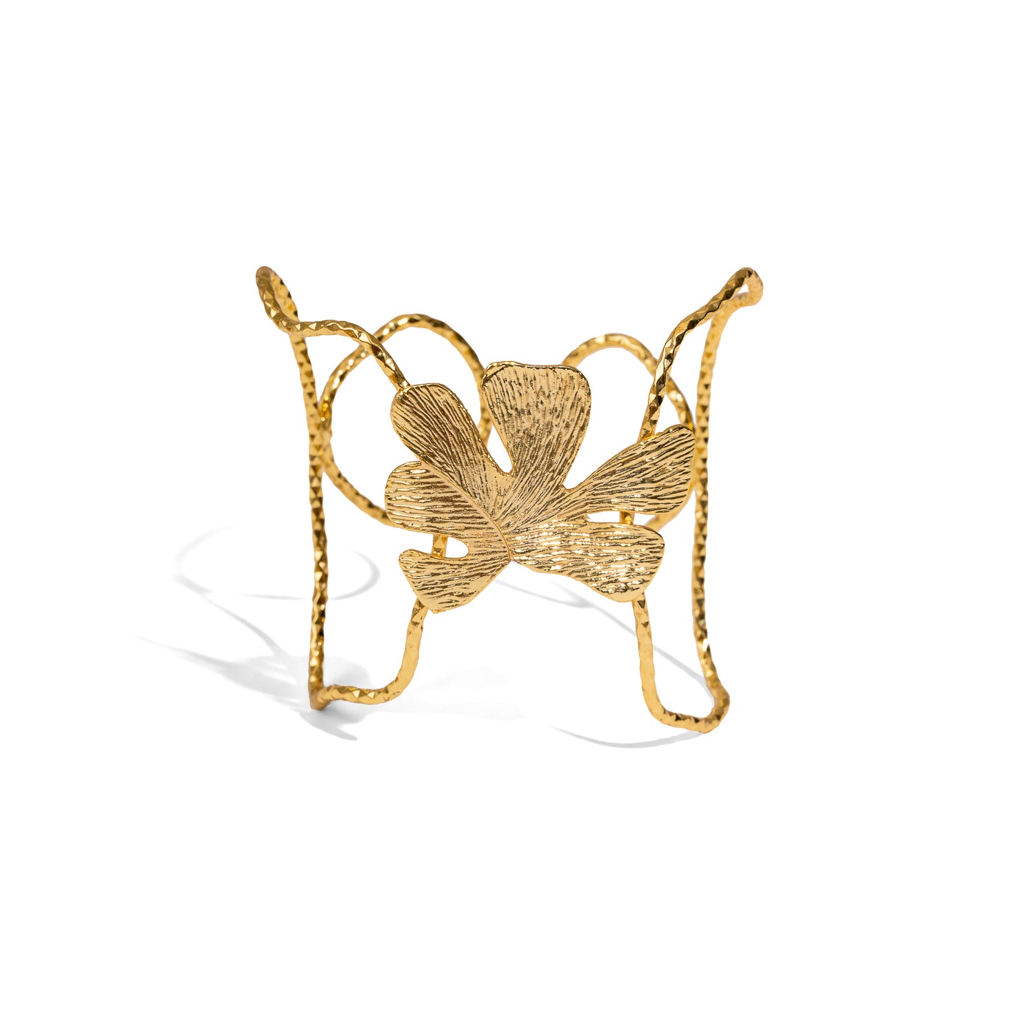 Gold bracelet with leaf design on a white background