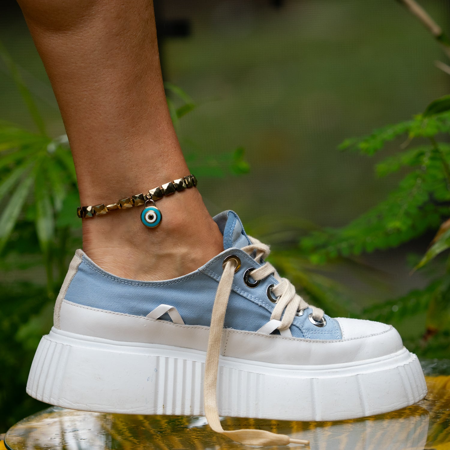 Stretch anklet with gold faceted hematite stones and enamel evil eye pendant