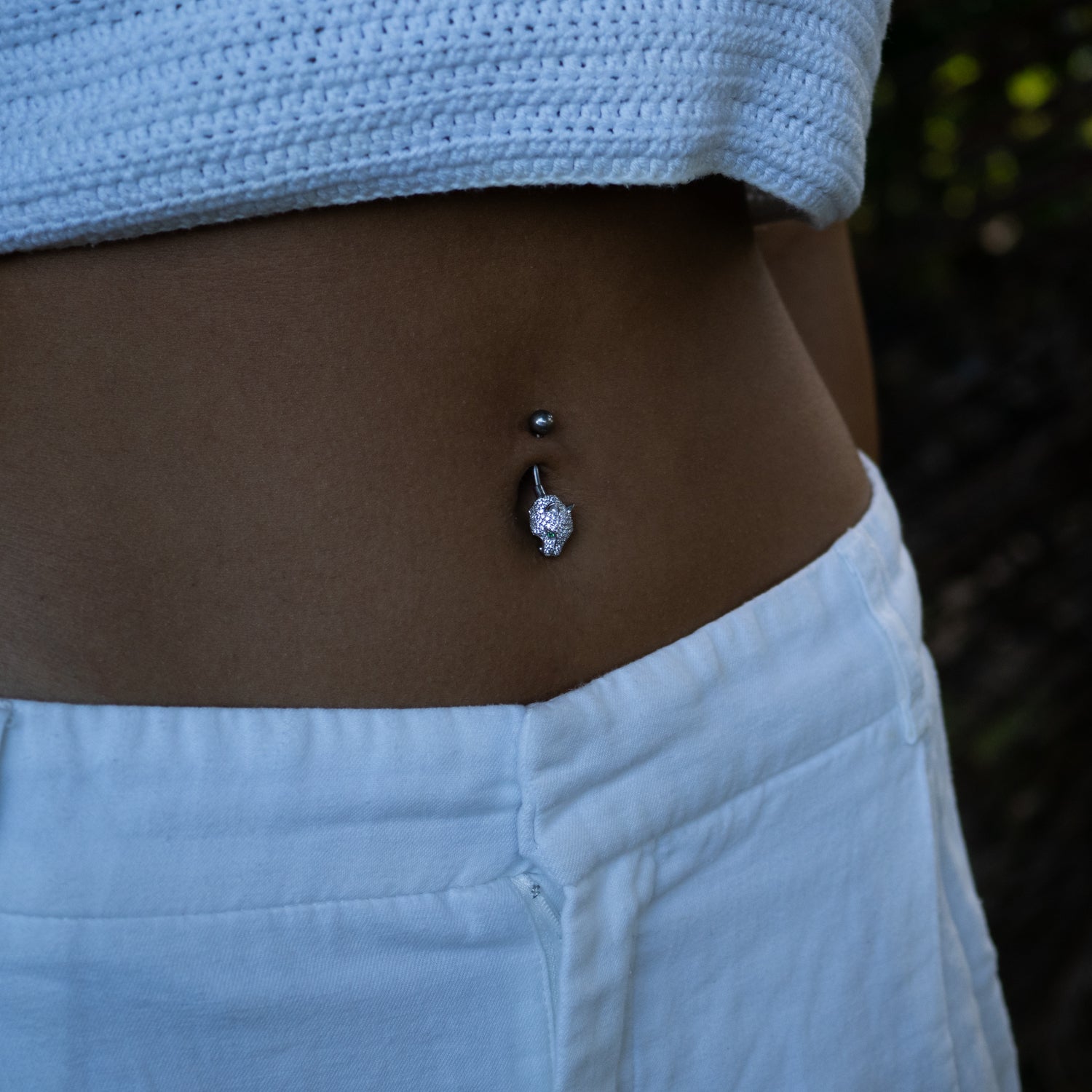Sterling silver belly piercing with a panther head, emerald green eyes, pavé CZ diamonds, and sleek, modern style