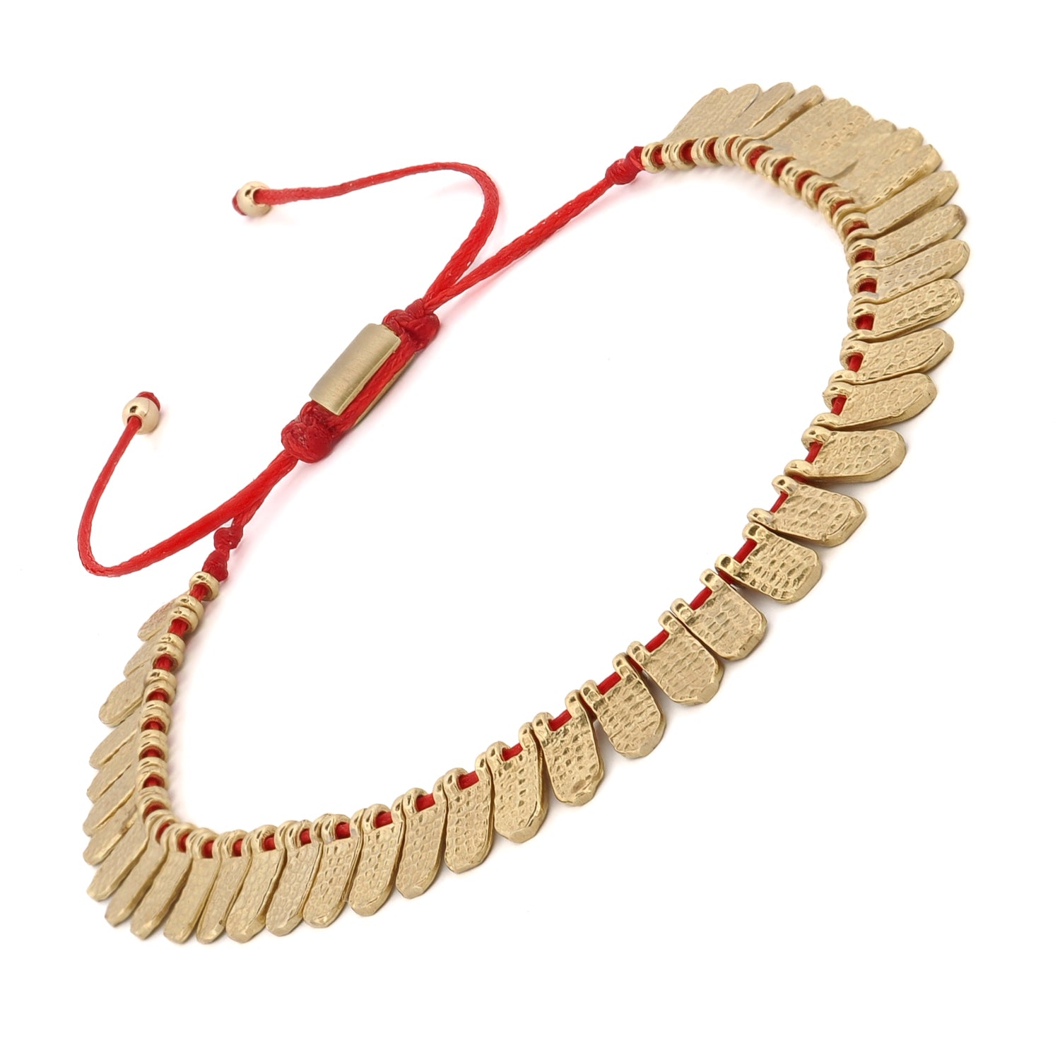 Adjustable red cord bracelet with shimmering 18K gold-plated charms, blending elegance and uniqueness.
