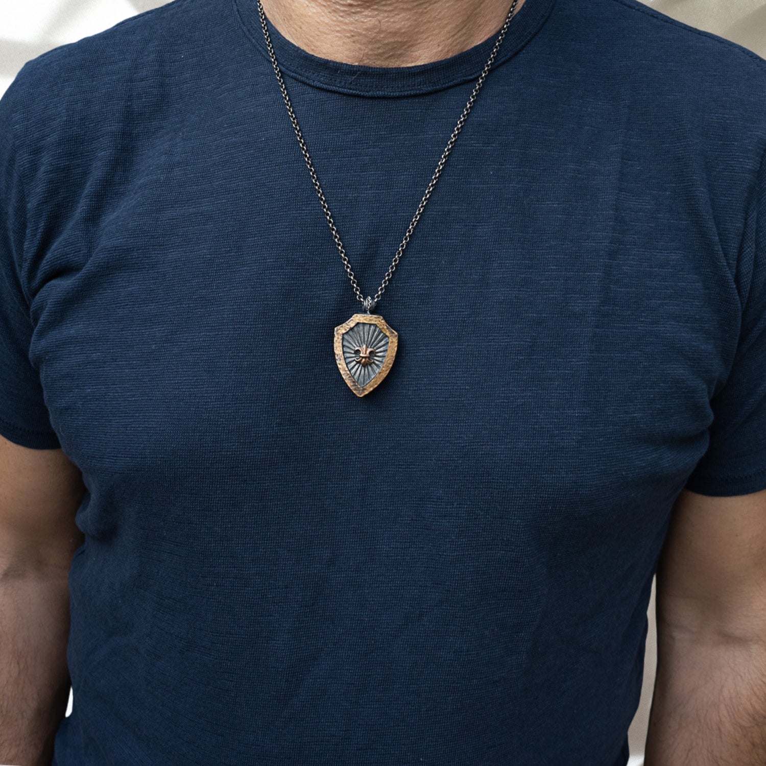Model showcasing Fleur de Lis Necklace - Handcrafted sterling silver chain with a stunning bronze-detailed pendant, adding grace and style to any ensemble.