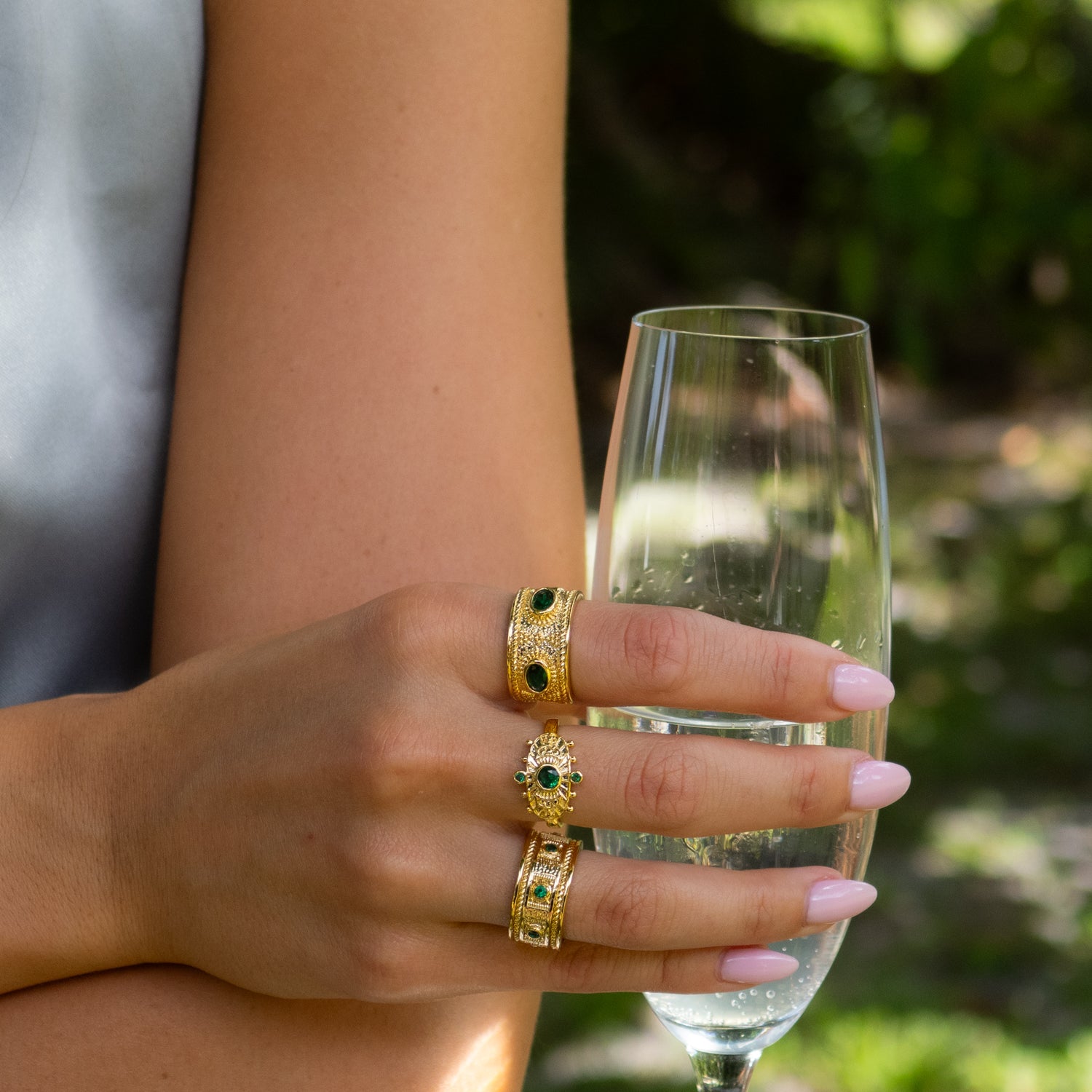 Handcrafted bronze ring plated in 24K gold featuring a vibrant emerald centerpiece.