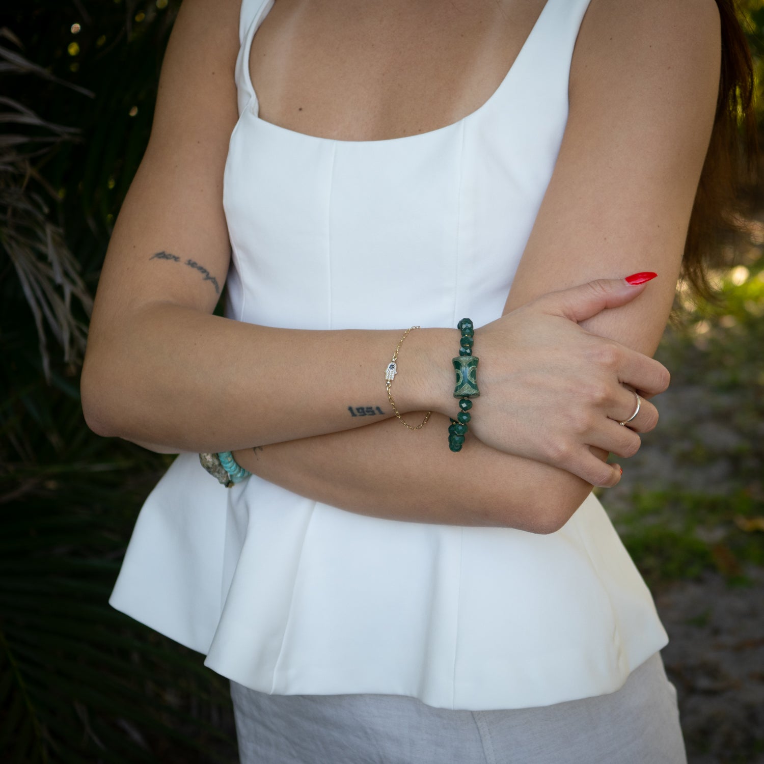 Green crystal beaded bracelet featuring brass spiral charm and gold hematite spacers.