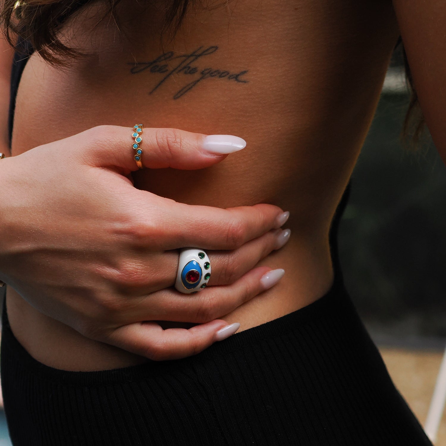 Striking white enamel ring featuring a guardian Evil Eye design with ruby and emerald stones on an 18K gold-plated band.