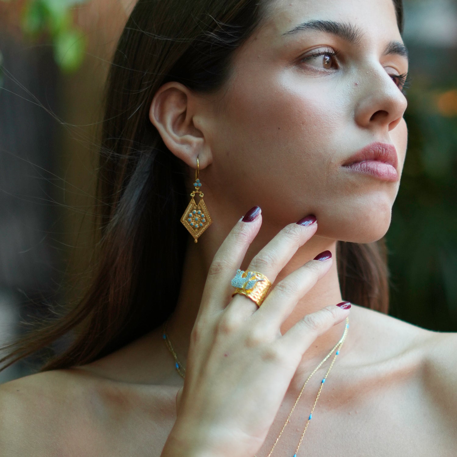 Chunky gold ring adorned with a turquoise elephant, crafted from 24k gold-plated brass with an adjustable band for everyday elegance.