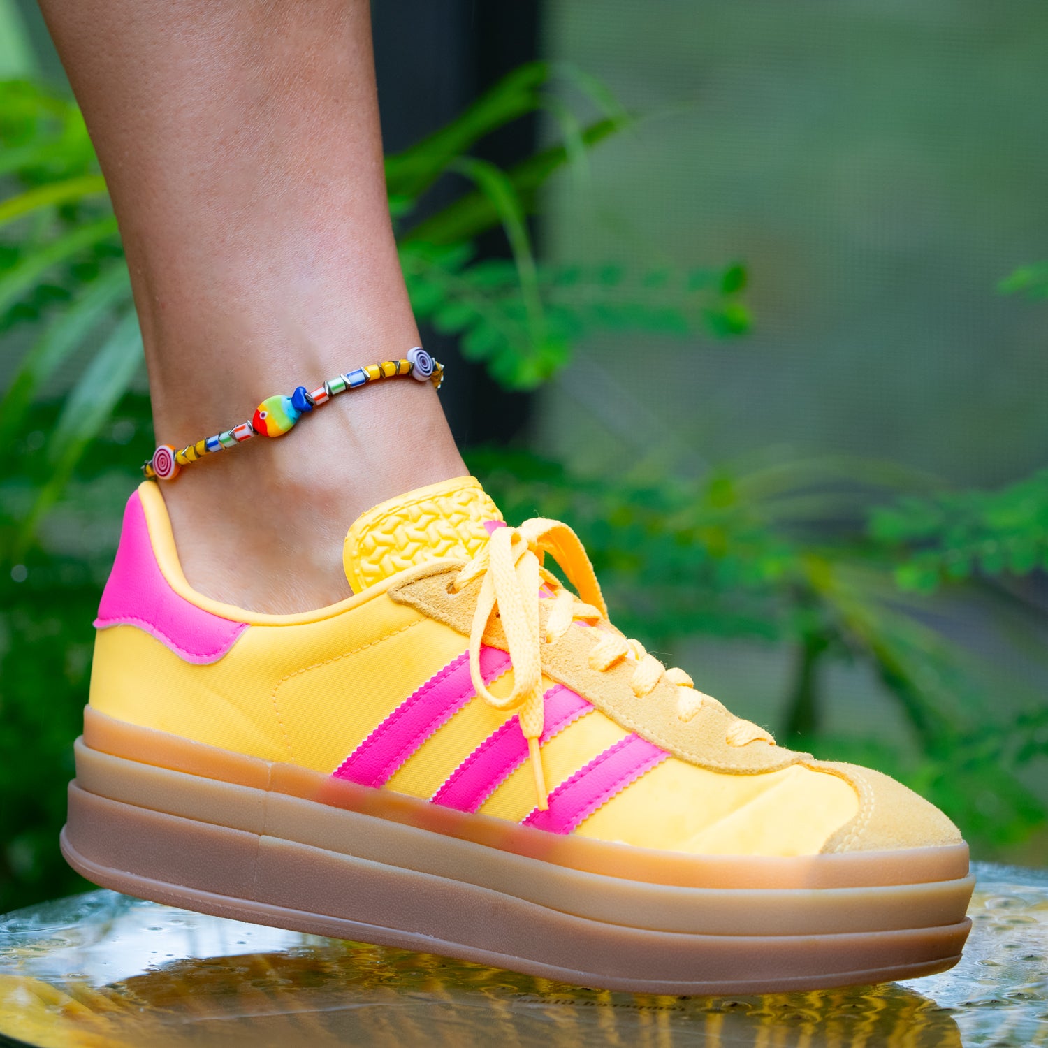 Playful ankle bracelet with smiley face bead and rainbow ocean vibes.