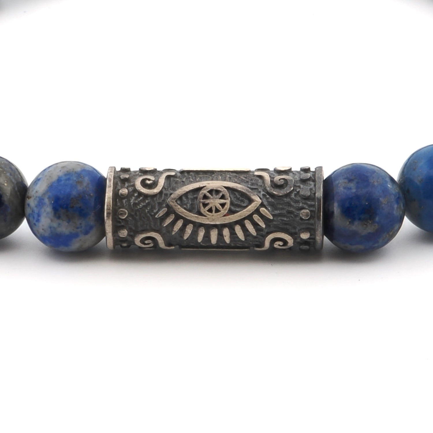 Close-up of a lapis lazuli beaded bracelet with a sterling silver Evil Eye symbol, offering wisdom and balance.