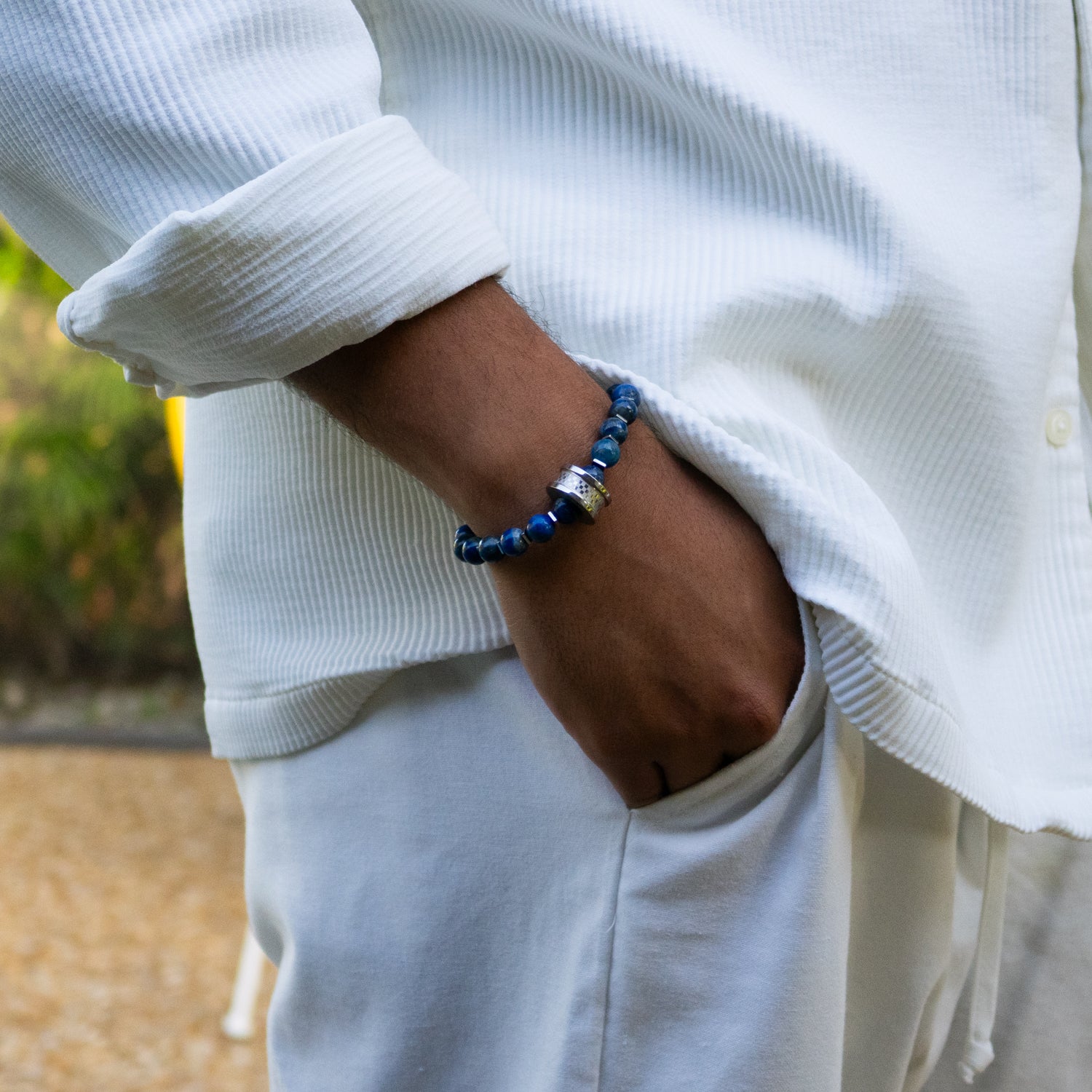 Lapis lazuli beaded bracelet with silver hematite spacers and intricate steel Amor centerpiece.