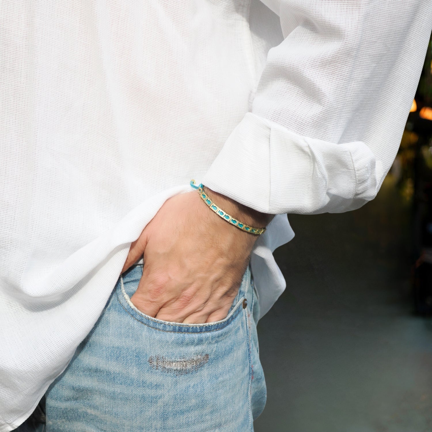 Lucky fish bracelet with bright turquoise cord and gold details, perfect for everyday blessings.