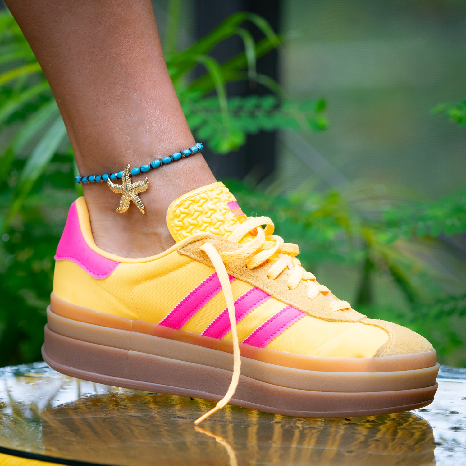 Stretchy turquoise anklet with yellow heart accent and gold-plated maritime charm.