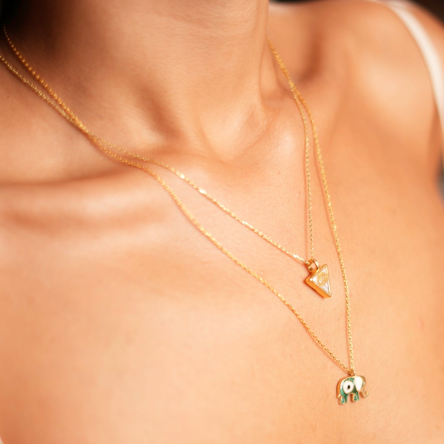 Elegant 18k gold-plated necklace featuring a pearl triangle pendant with a gold evil eye talisman, 18" length with 2'' extender.