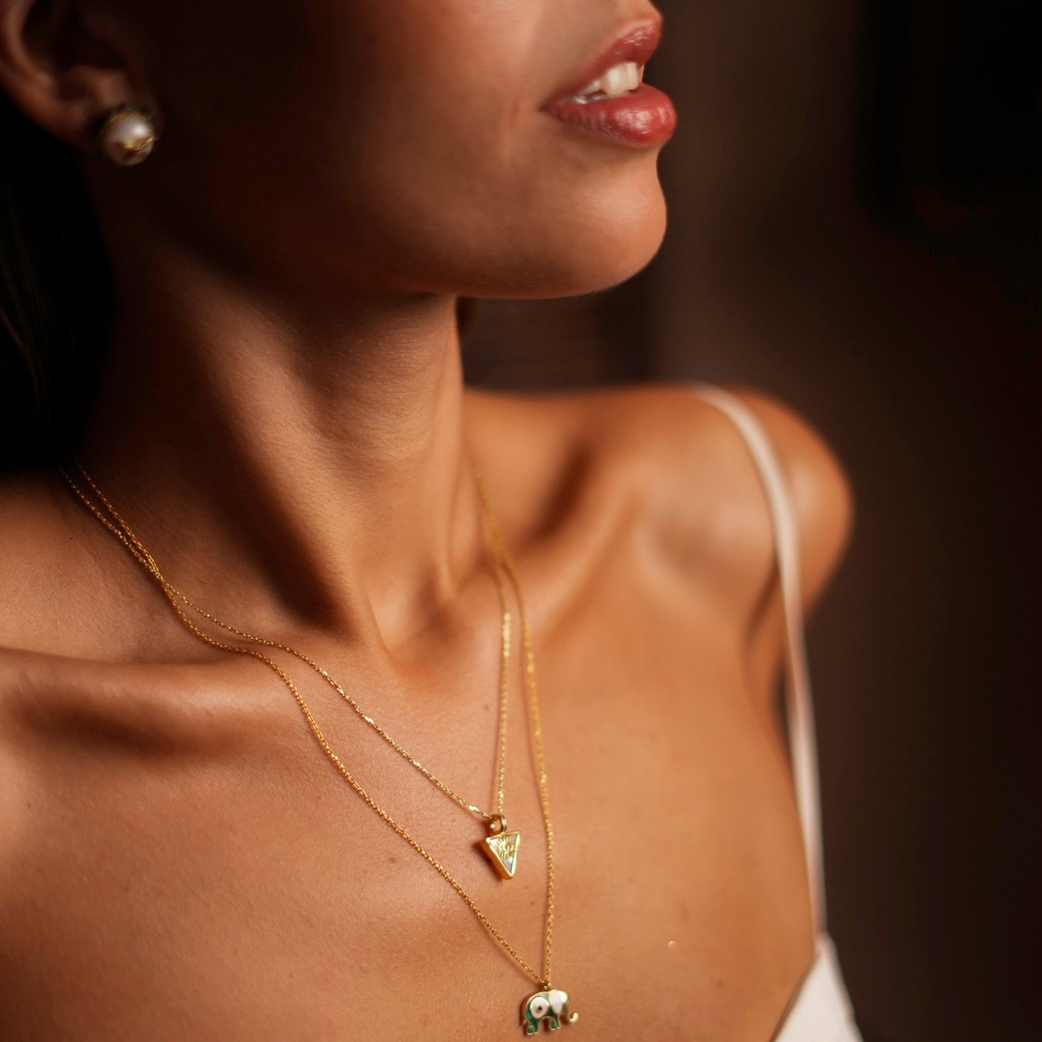 Sophisticated necklace with a pearl triangle pendant and gold evil eye talisman, crafted in 18k gold-plated sterling silver.