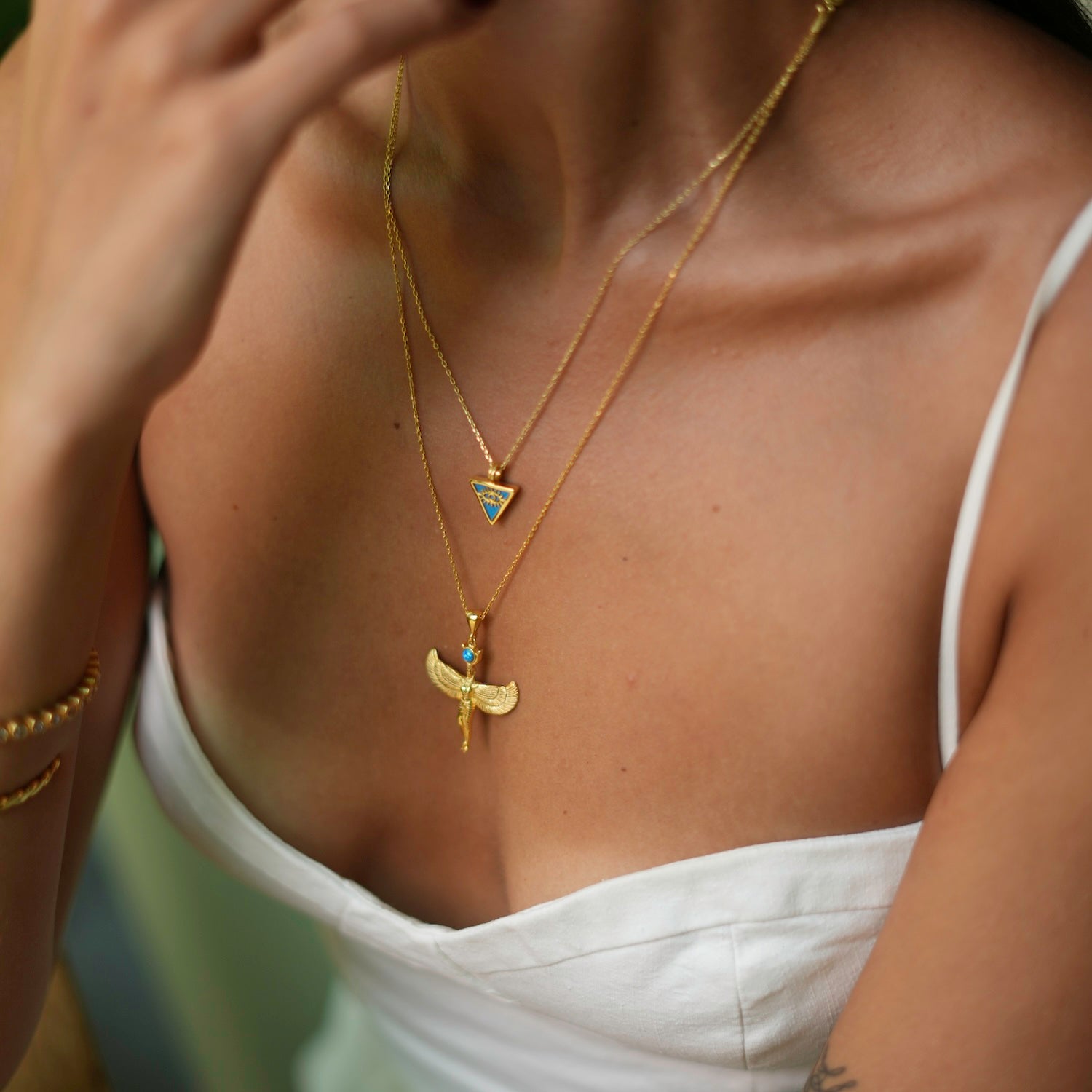 Elegant turquoise triangle pendant necklace adorned with a gold evil eye talisman, crafted in 18k gold-plated sterling silver.