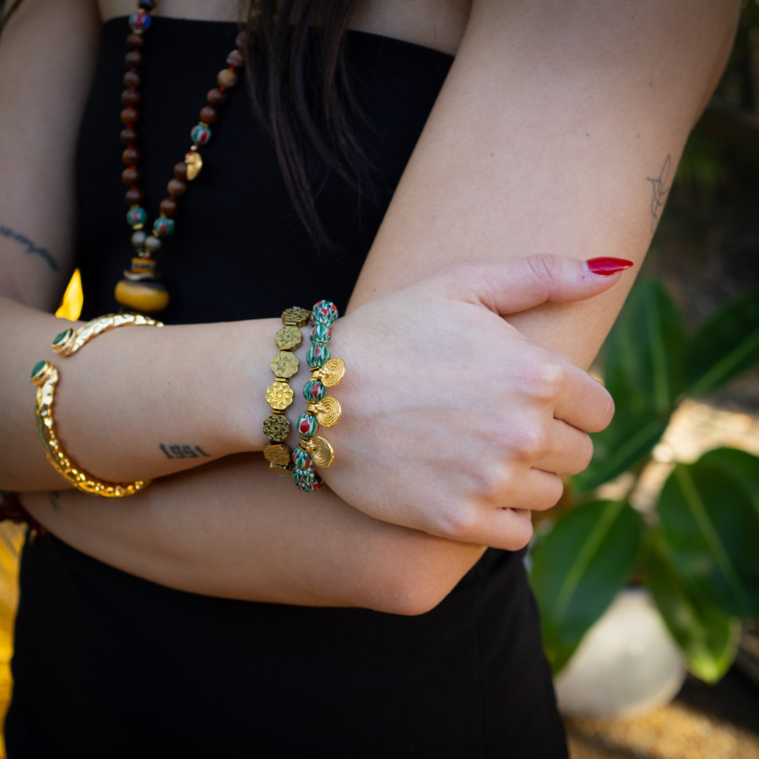 Gold and gemstone bracelet set with spiral symbols and floral-engraved hematite beads