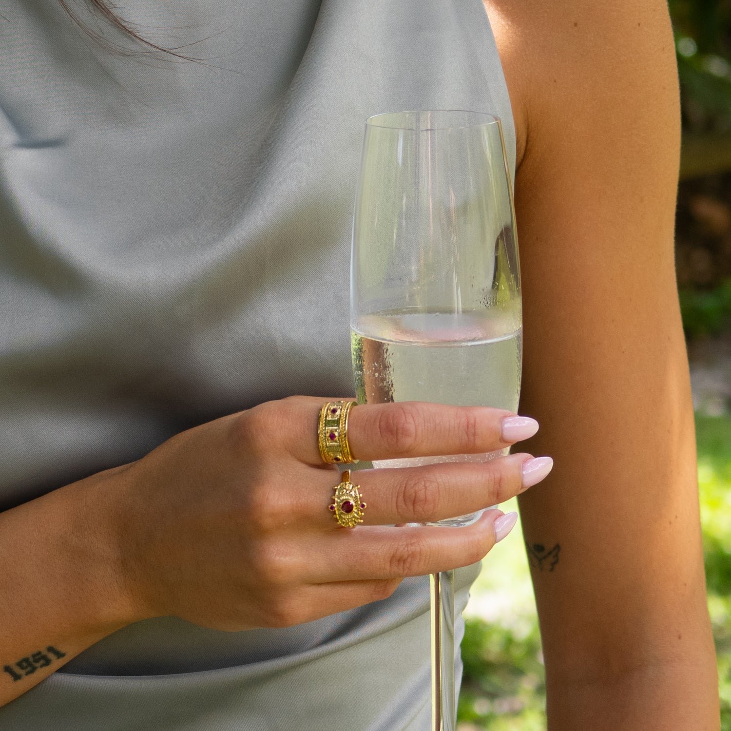Close-up of gold ring with ruby gems symbolizing passion and engraved mystical patterns.