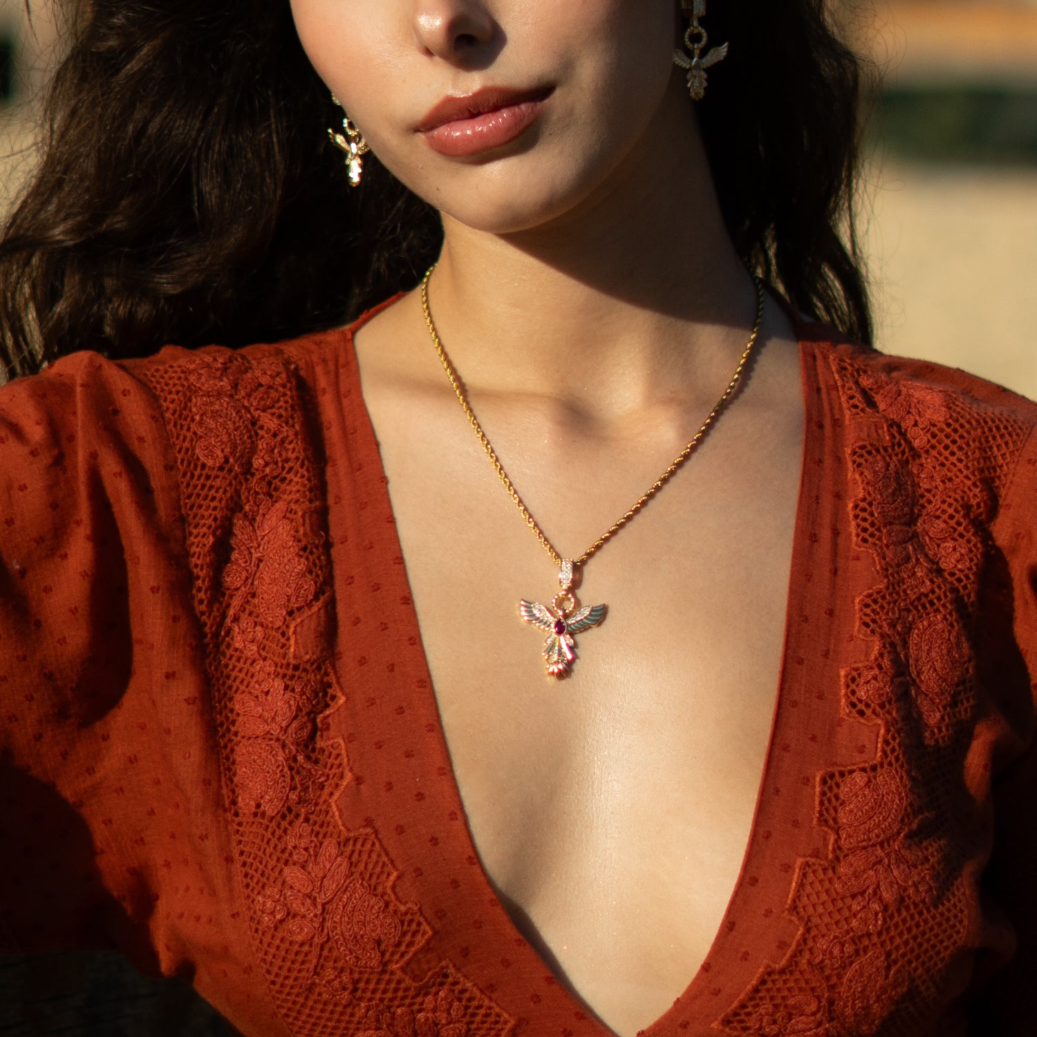 Bold spiritual necklace with gold phoenix and red gemstone